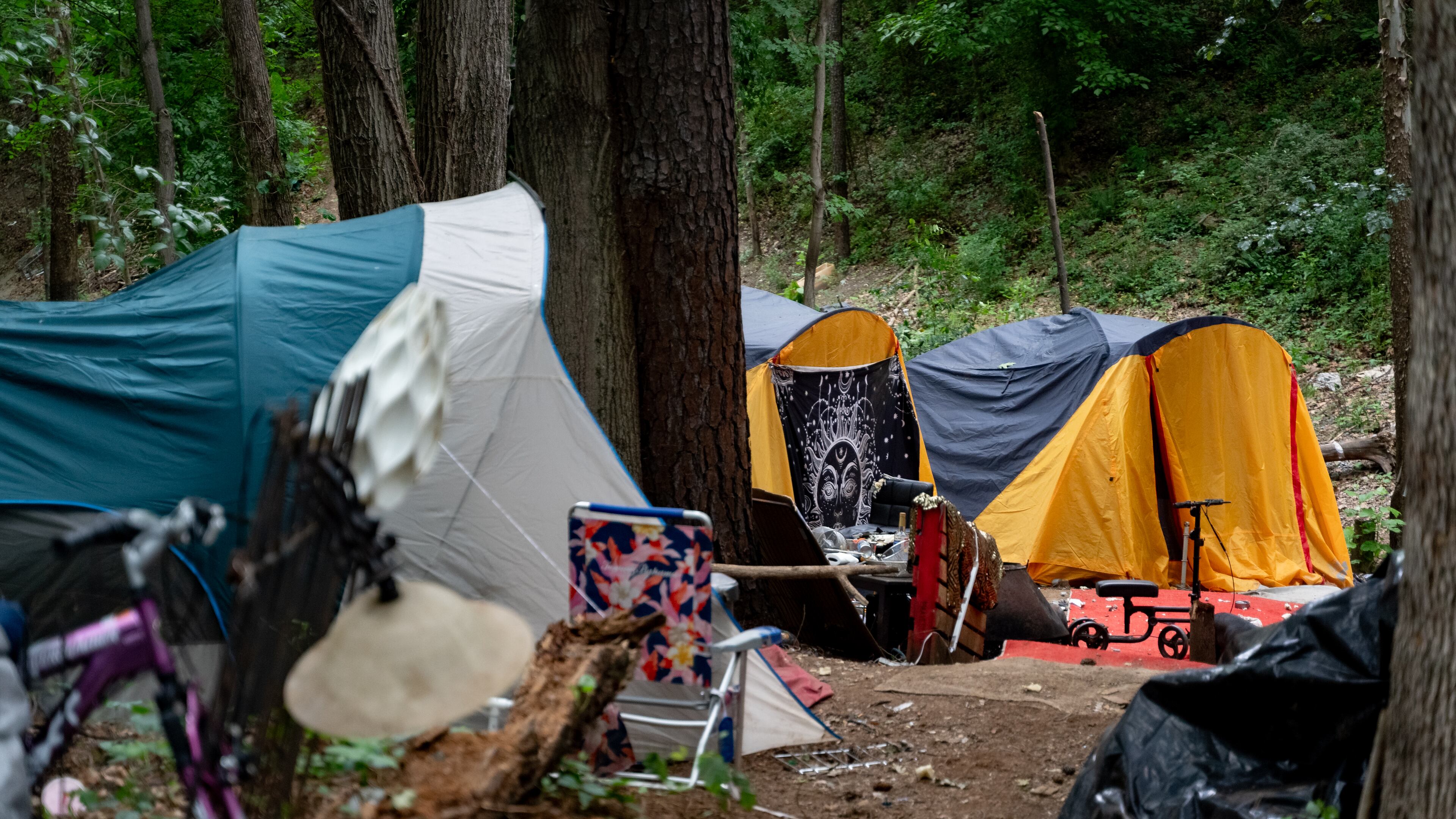 Multiple tents are set up in the woodline next to interstate 85. Tracy Woodard is a social worker with InTown Cares, a homeless advocacy group serving the Atlanta metro area. Friday, May 17, 2024 (Ben Hendren for the Atlanta Journal Constitution)