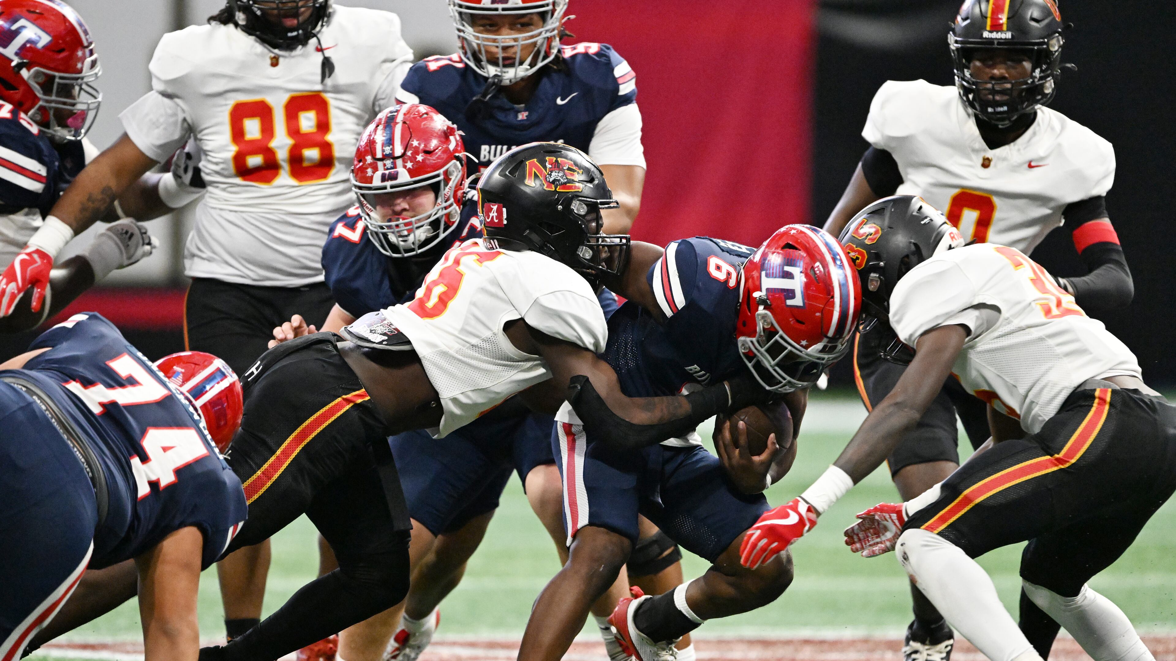 Northeast's linebacker Tailen Sampson (center in white) makes a tackle during the Class A-Division I state title game in December in Atlanta. Sampson, Northeast's leading tackler last season, was named a 2025 preseason all-state player in the A-Division I public classification. (Hyosub Shin/AJC 2024)