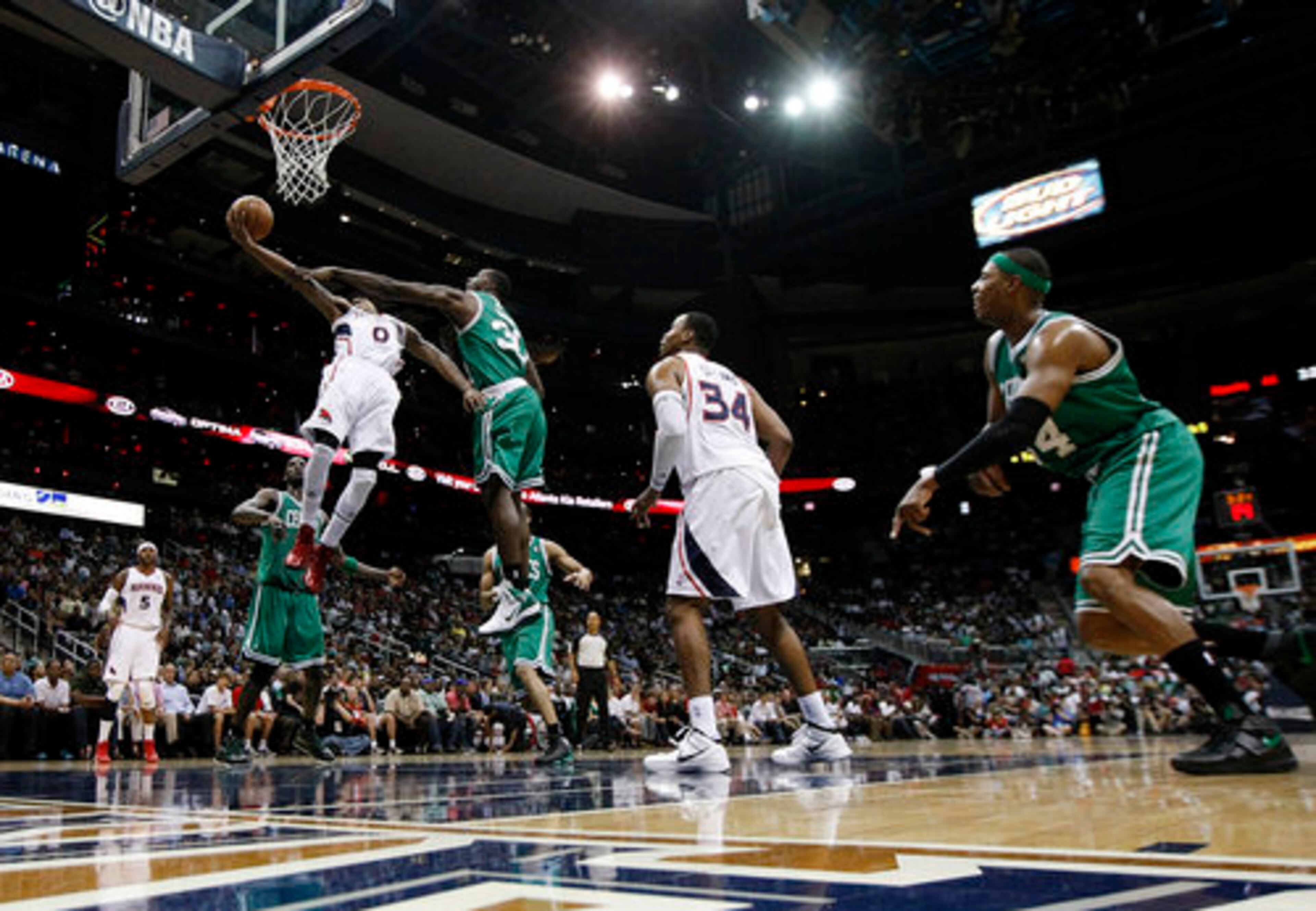 Atlanta Hawks guard Jeff Teague soars to the basket past Boston Celtics Brandon Bass for 2-points at Philips Arena in Atlanta, Sunday, April 29, 2012.