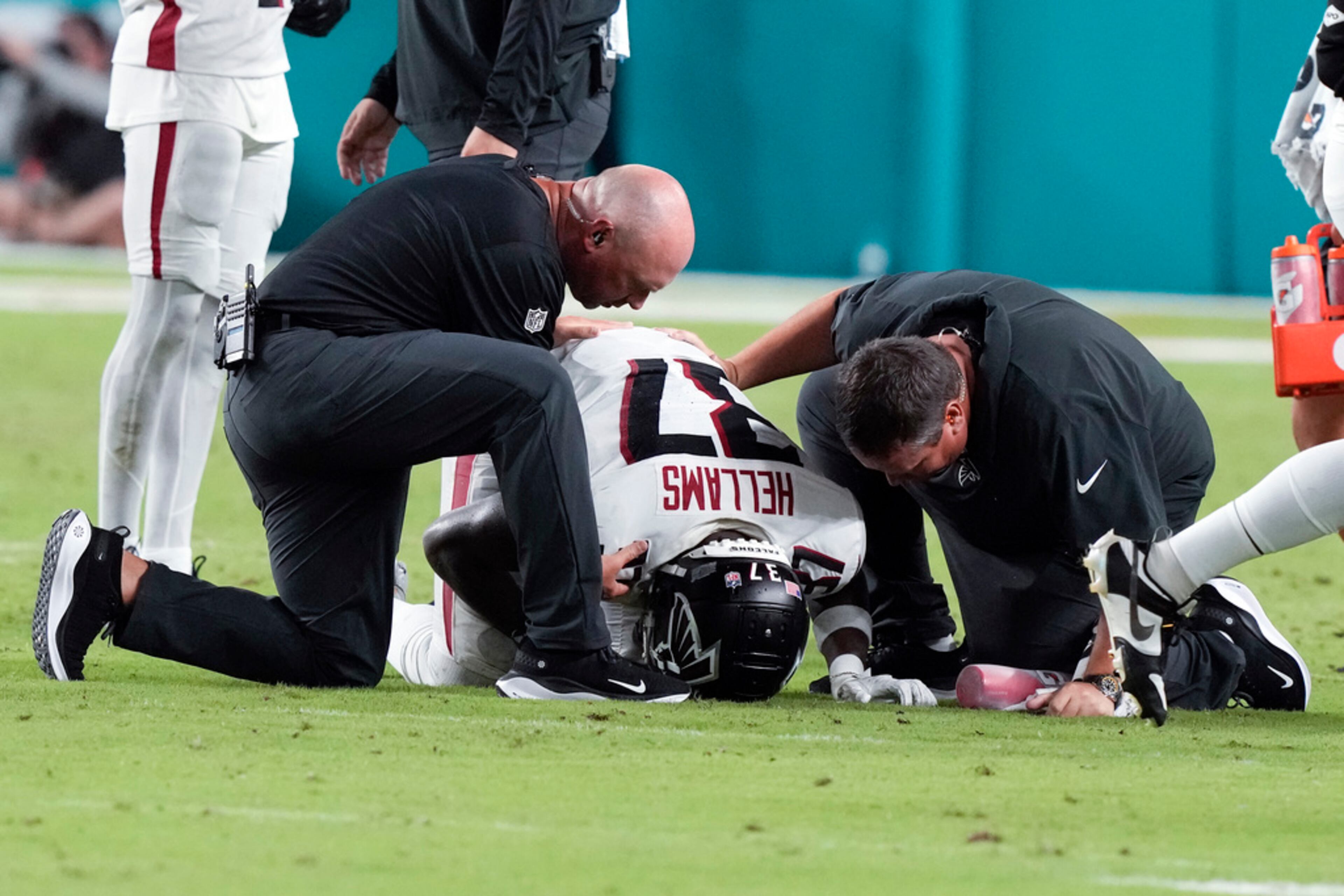 Atlanta Falcons safety DeMarcco Hellams (37) is tended to by memeberas of the Falcons training staff after being injured in the second half of a preseason NFL football game against the Miami Dolphins, Friday, Aug. 11, 2023, in Miami Gardens, Fla. (AP Photo/Marta Lavandier)
