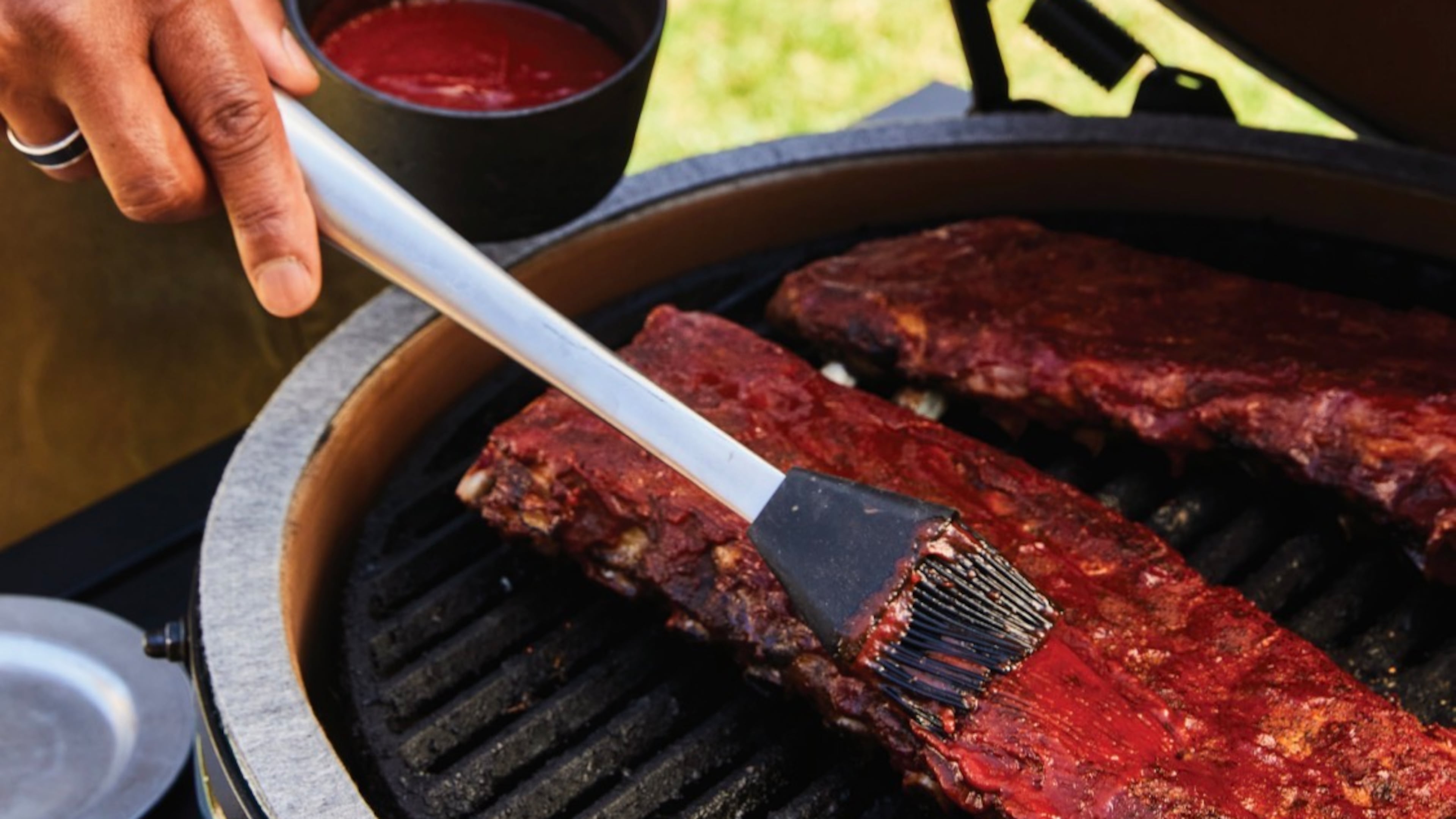 Chef David Rose adds a thin layer of BBQ sauce onto smoked ribs during the final stage of cooking, creating a glossy, caramelized finish with a perfect sticky glaze. (Courtesy of Kathryn McCrary)
