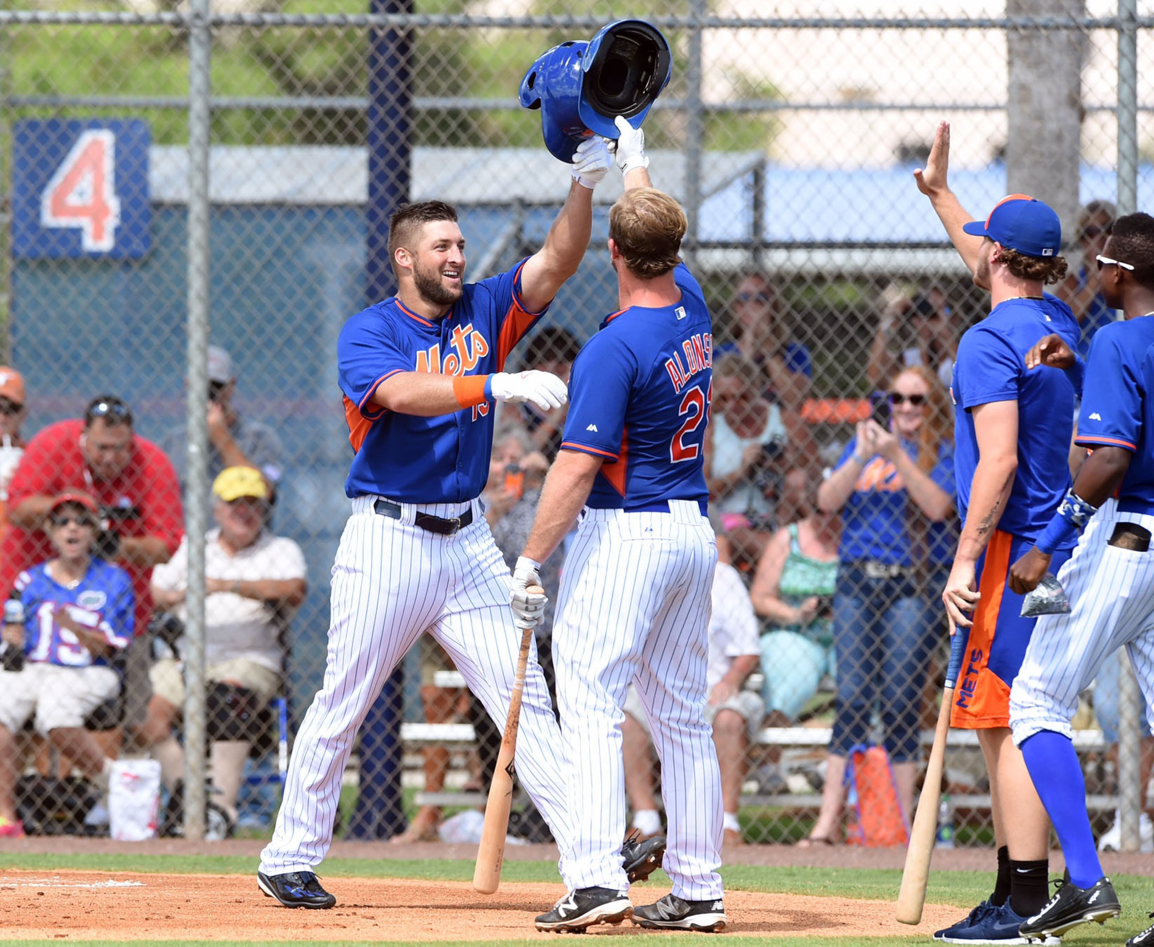 Tim Tebow is greeted by Peter Alonso after hitting a solo home run in his first at bat during the first inning of his first instructional league baseball game for the New York Mets against the St. Louis Cardinals instructional club Wednesday, Sept. 28, 2016, in Port St. Lucie, Fla. (Jeremiah Wilson/The Stuart News via AP)