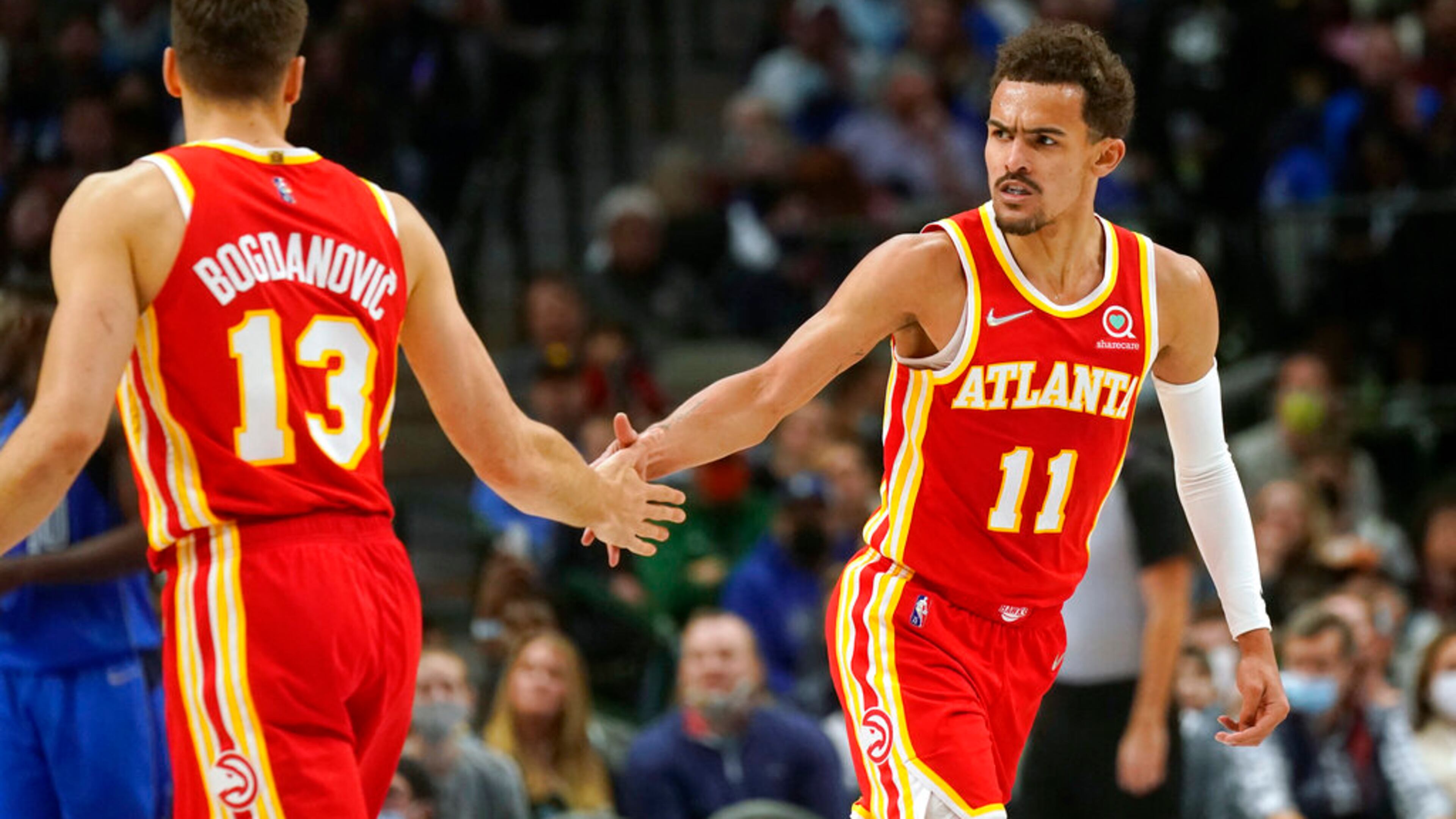 Atlanta Hawks guards Trae Young (11) gives congrats to teammate Bogdan Bogdanovic (13) during the second half of an NBA basketball game against the Dallas Mavericks in Dallas, Sunday, Feb. 6, 2022. (AP Photo/LM Otero)