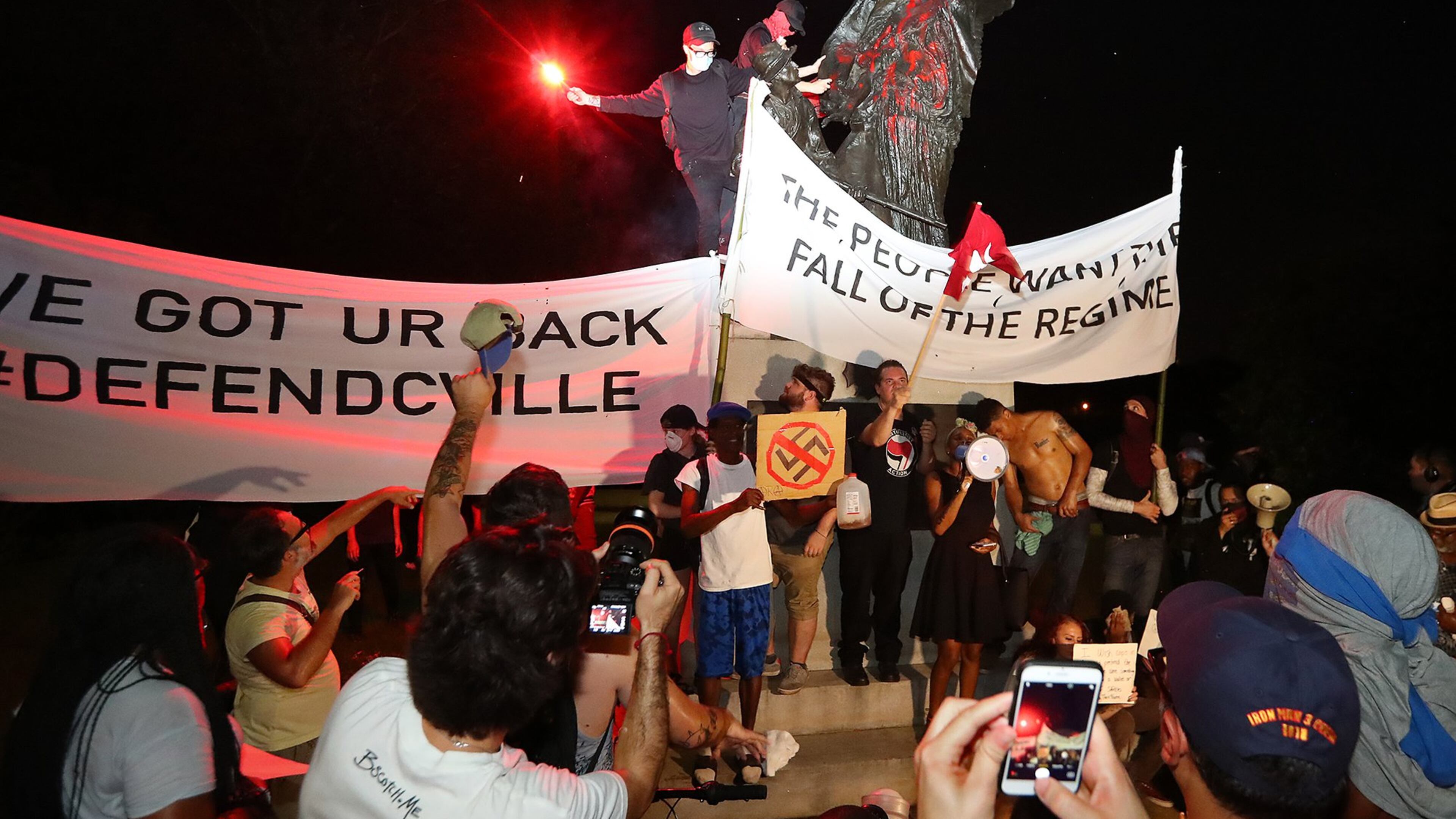 Anti-fascist activists climbed a Piedmont Park monument Sunday near the conclusion of an anti-white nationalism march in response to violence in Virginia. So-called antifa protesters were a small but visible part of the rally in downtown Atlanta Sunday. CURTIS COMPTON / CCOMPTON@AJC.COM