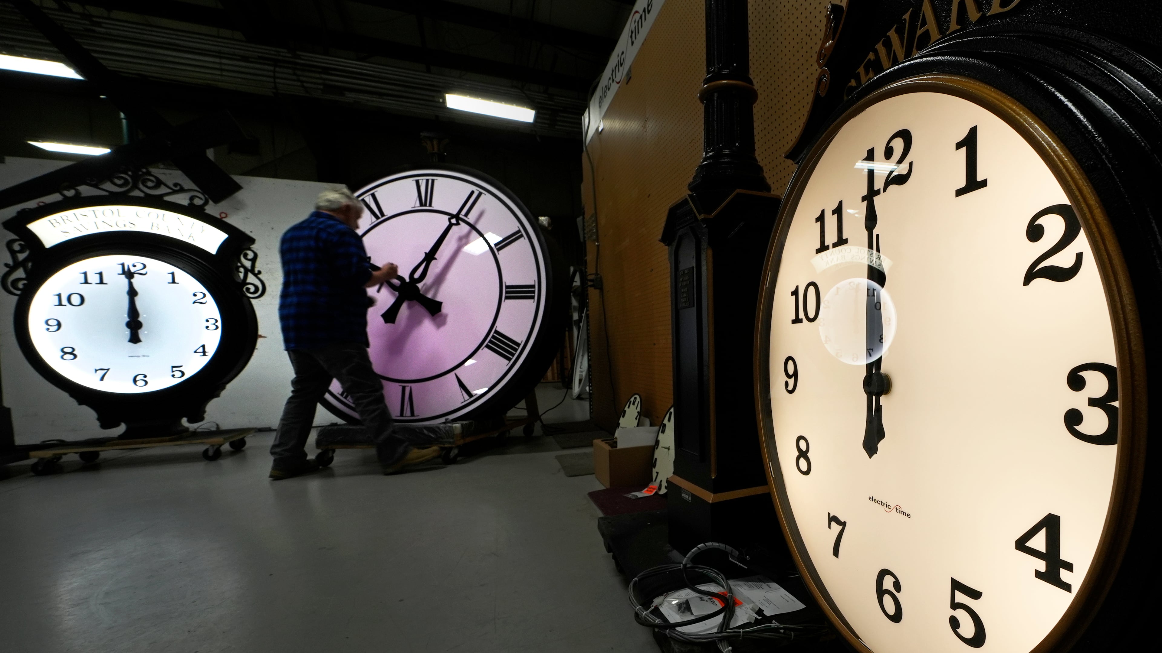 FILE - Clockmaker Scott Gow adjusts the hands of a clock at the Electric Time Company, Oct. 30, 2024, in Medfield, Mass. (AP Photo/Charles Krupa, File)
