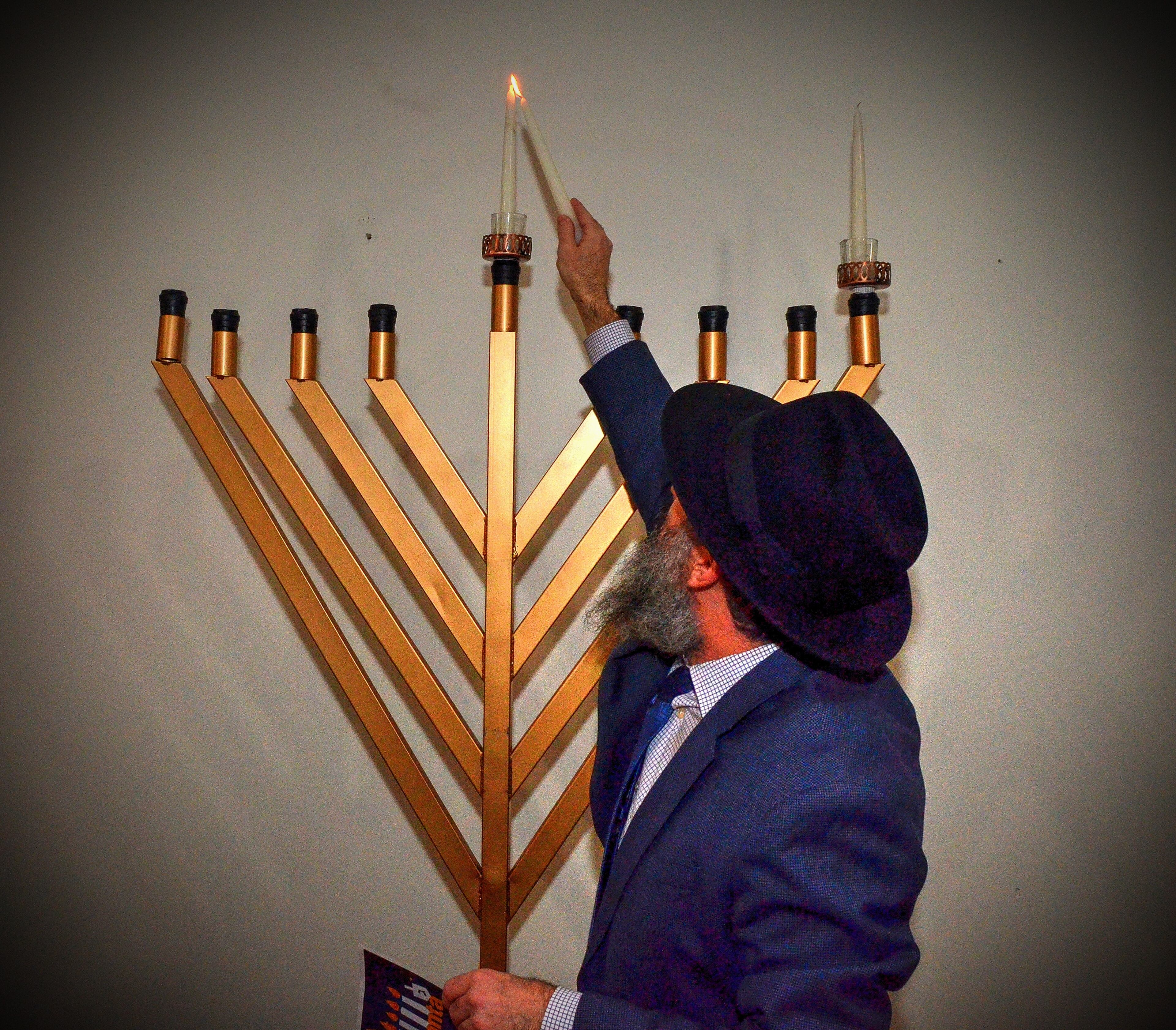 191222 Atlanta, Ga: Rabbi Eliyahu Schusterman lights the first candle for the celebration. Menorah lighting and celebration sponsored by Chabad Intown and MJCAA Day Camps. Music, entertainment, Dreidels, doughnuts, hot latkes, gelt drop and more. Children who RSVP will recieve and Chanukah gift. All photos taken Sunday 12/22/2019 at Chabad Intown, along the Beltline in Atlanta, Ga. (Photo credit Chris Hunt Photography) for 122319hanukkah