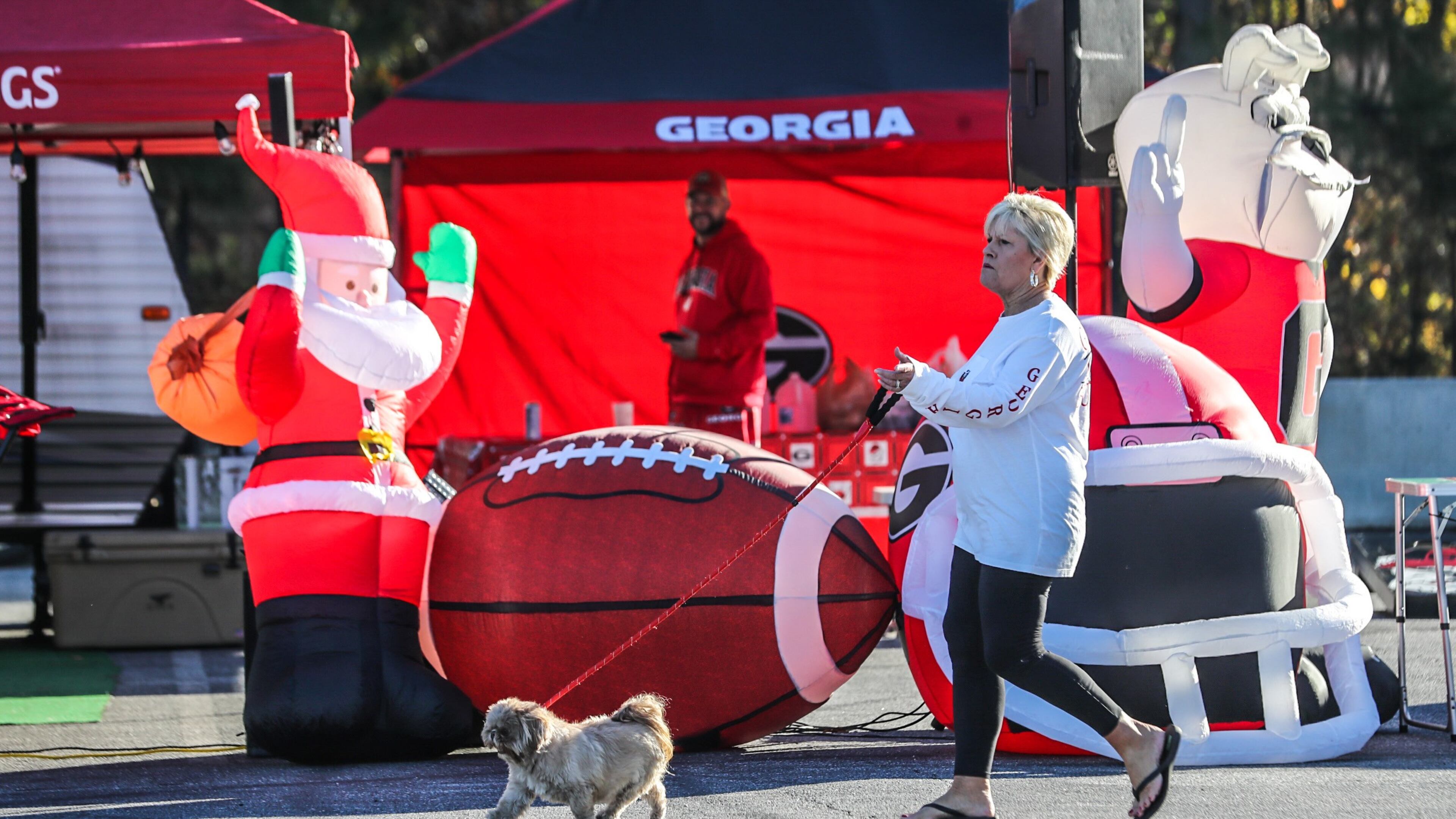 Thomaston resident Janet Pitts walks her dog Annie in the sunshine Friday at the Marshalling Yard at the Georgia World Congress Center.