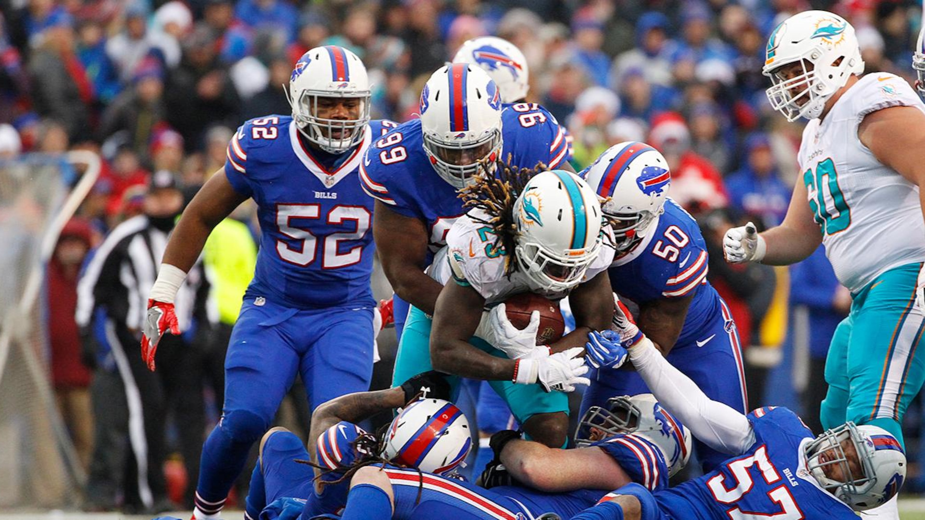 Miami Dolphins running back Jay Ajayi (23) is tackled by Buffalo Bills' Lorenzo Alexander (57), Marcell Dareus (99) and Ramon Humber (50) during the second half of an NFL football game Saturday, Dec. 24, 2016, in Orchard Park, N.Y. (AP Photo/Bill Wippert)