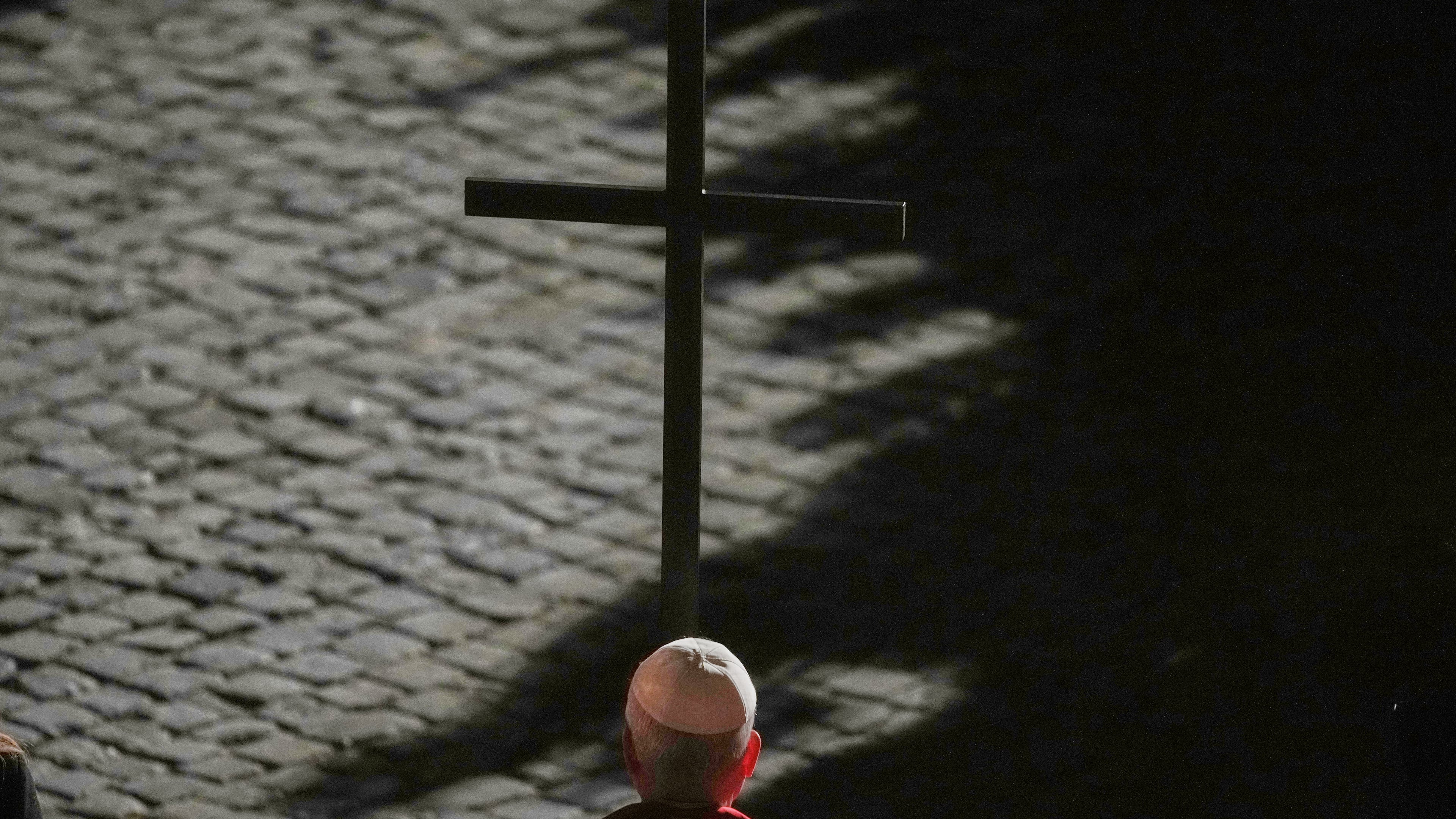 Pope Leo XIV carries a lightweight, 1.5-meter (5-foot) wooden cross during the Via Crucis, the torchlit Good Friday Stations of the Cross procession at the Colosseum in Rome, Friday, April 3, 2026, which symbolically retraces Jesus Christ's steps to his crucifixion on Calvary in Jerusalem. (AP Photo/Alessandra Tarantino)