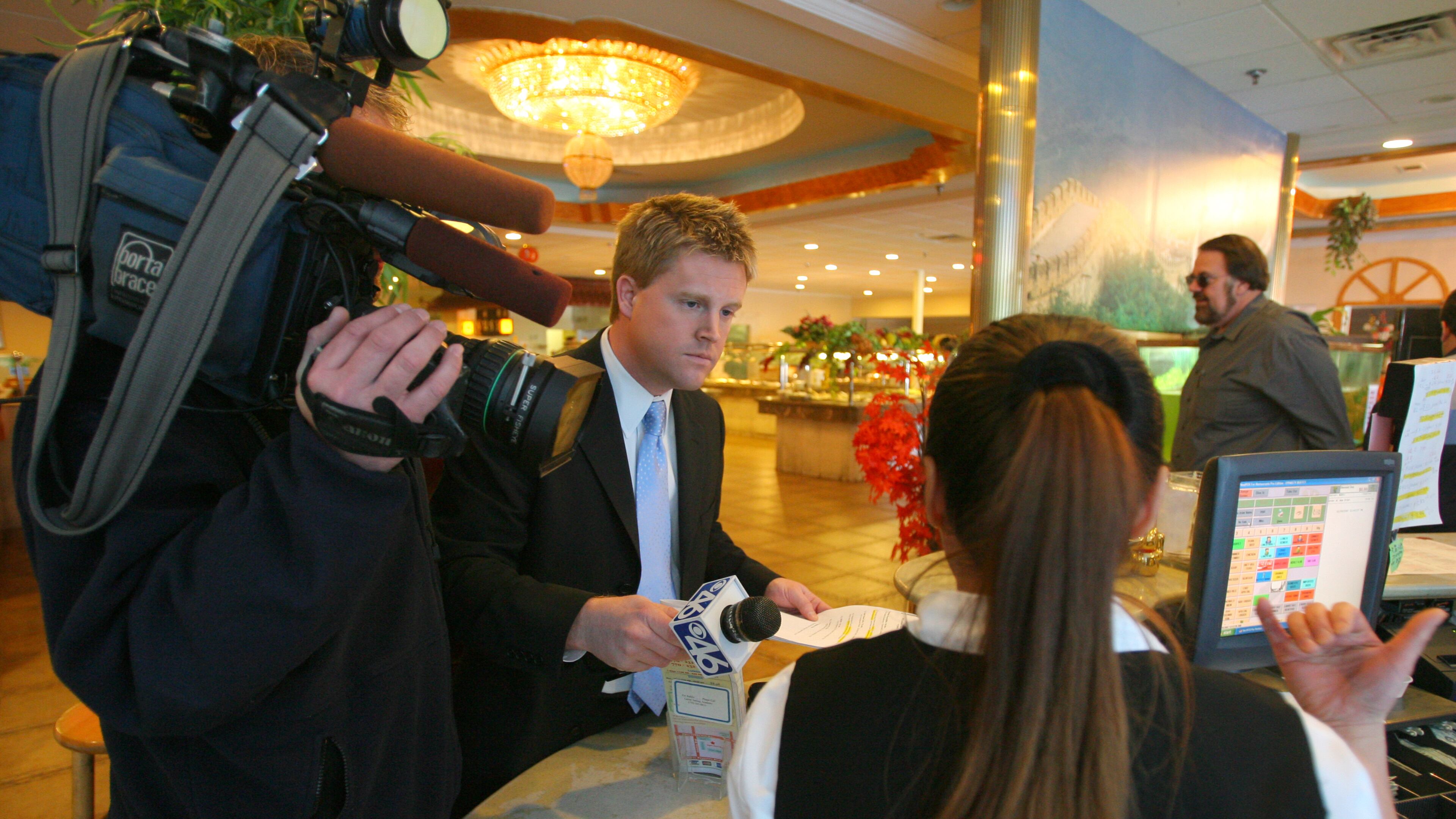071127 Duluth,GA: WGCL reporter, Adam Murphy, and photographer A.J. Willen, confront a worker at the Super New China Buffet as part of his Restaurant Report Card" which zings restaurants with failing health inspections. Murphy also visits restaurants with good health inspection scores and praises them for their good work. (Brant Sanderlin photo/Staff)