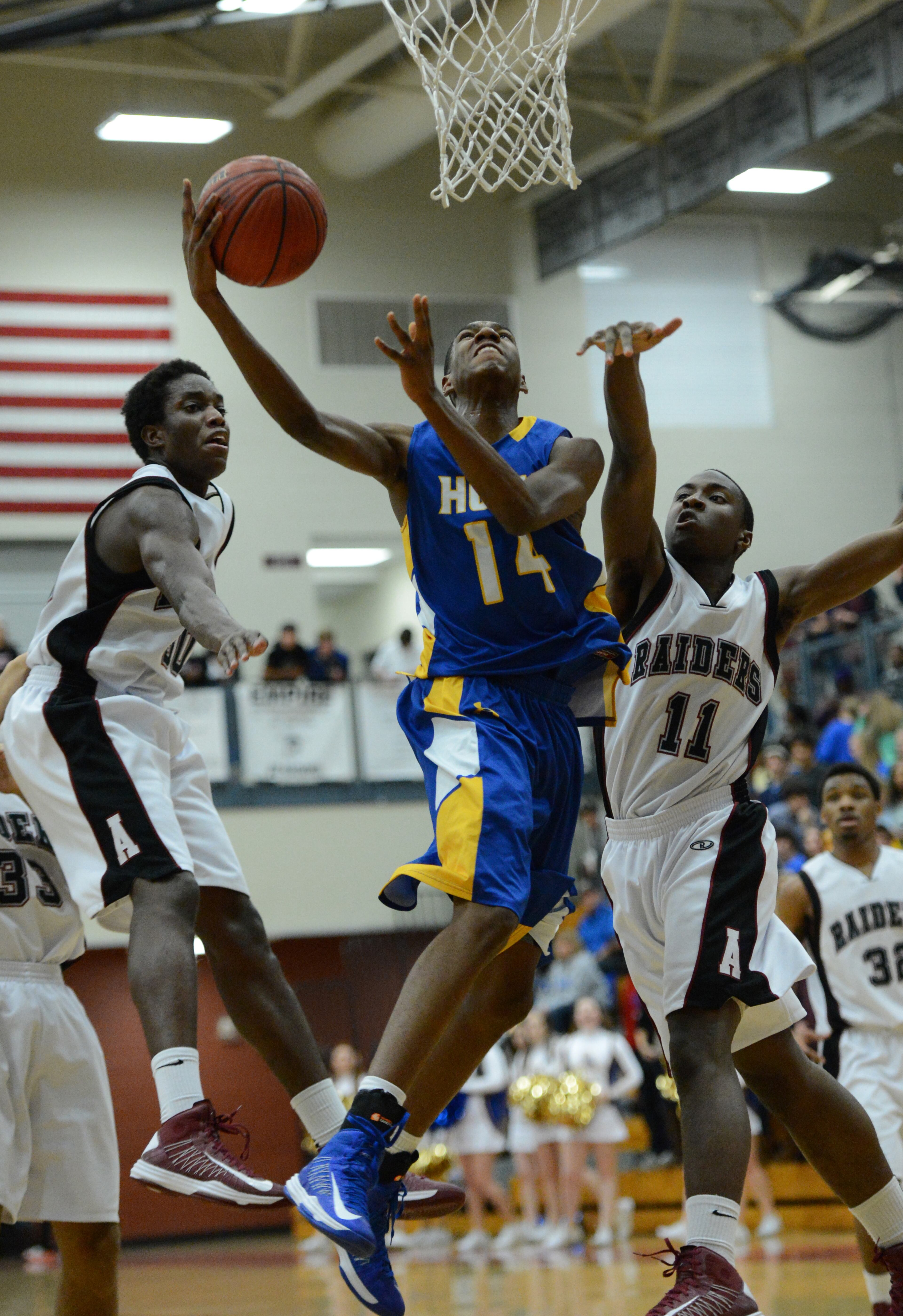 Chattahoochee's Marcus Sheffield (14) shoots between Alpharetta's Bjorn Walker (left) and Alpharetta's Afam Maduka (11) in the first half.