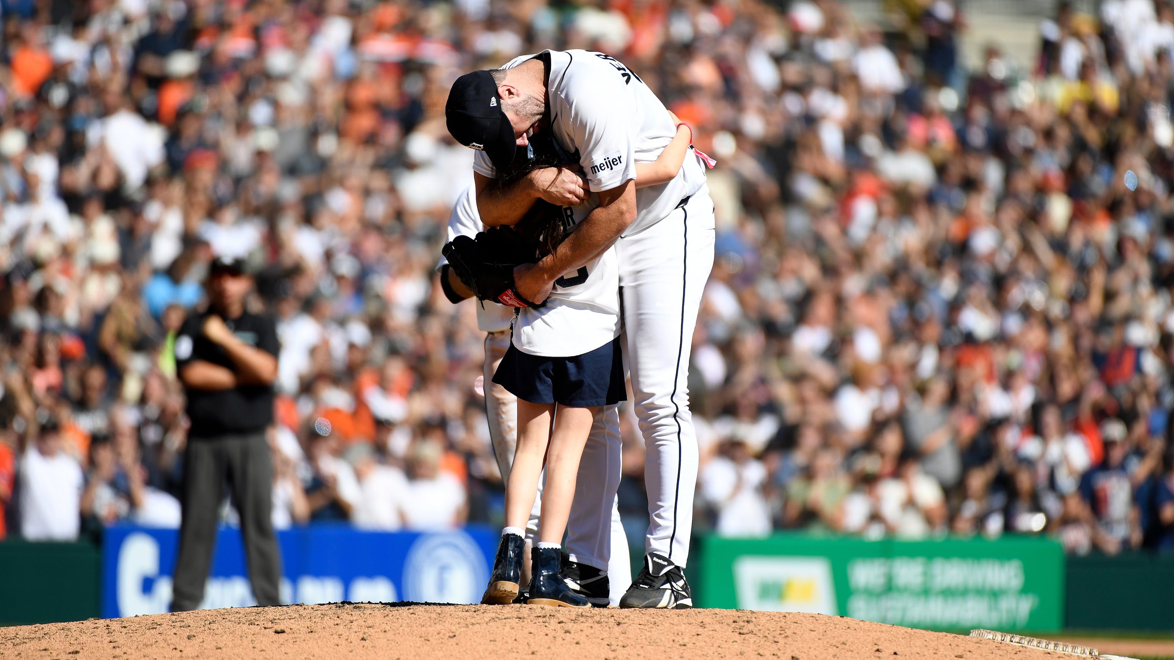 Genevieve Verlander, left, hugs her dad, Detroit Tigers starting pitcher Justin Verlander, during the sixth inning of a baseball game against the Pittsburgh Pirates, Saturday, Sept. 26, 2026, in Detroit. (AP Photo/Jose Juarez)
