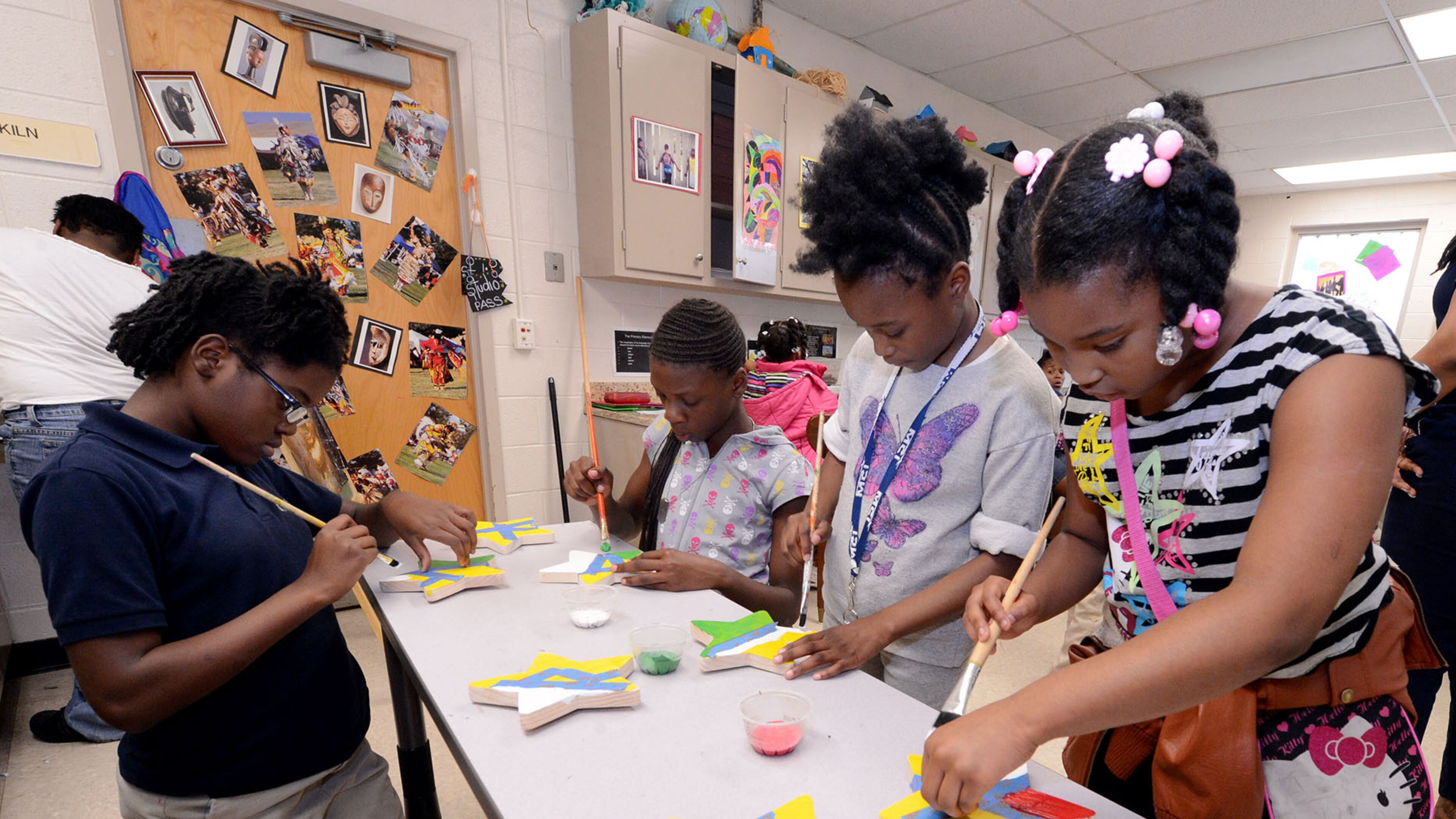 Shantwon Perry, left, Elise Harden, Keniyah Anderson, and Diamond Daugherty paint stars for a mural during an after-school program at the Center of Hope-Thomasville in Atlanta. The Community Foundation for Greater Atlanta received a grant this year from the Coca-Cola Foundation to support the city of Atlanta's Centers of Hope program.
