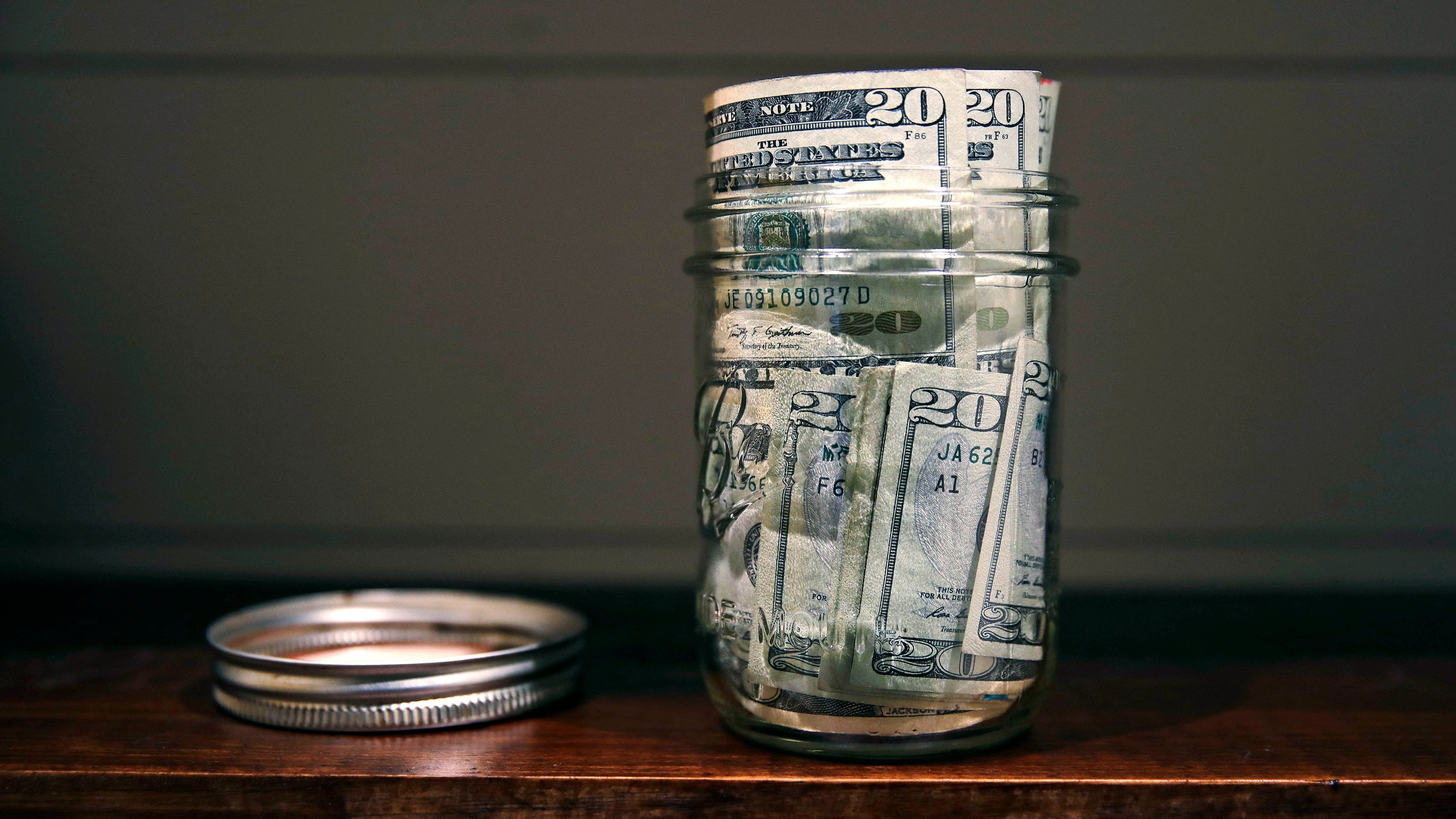 FILE - A canning jar filled with money sits on a shelf in East Derry, N.H., June 15, 2018. (AP Photo/Charles Krupa, File)