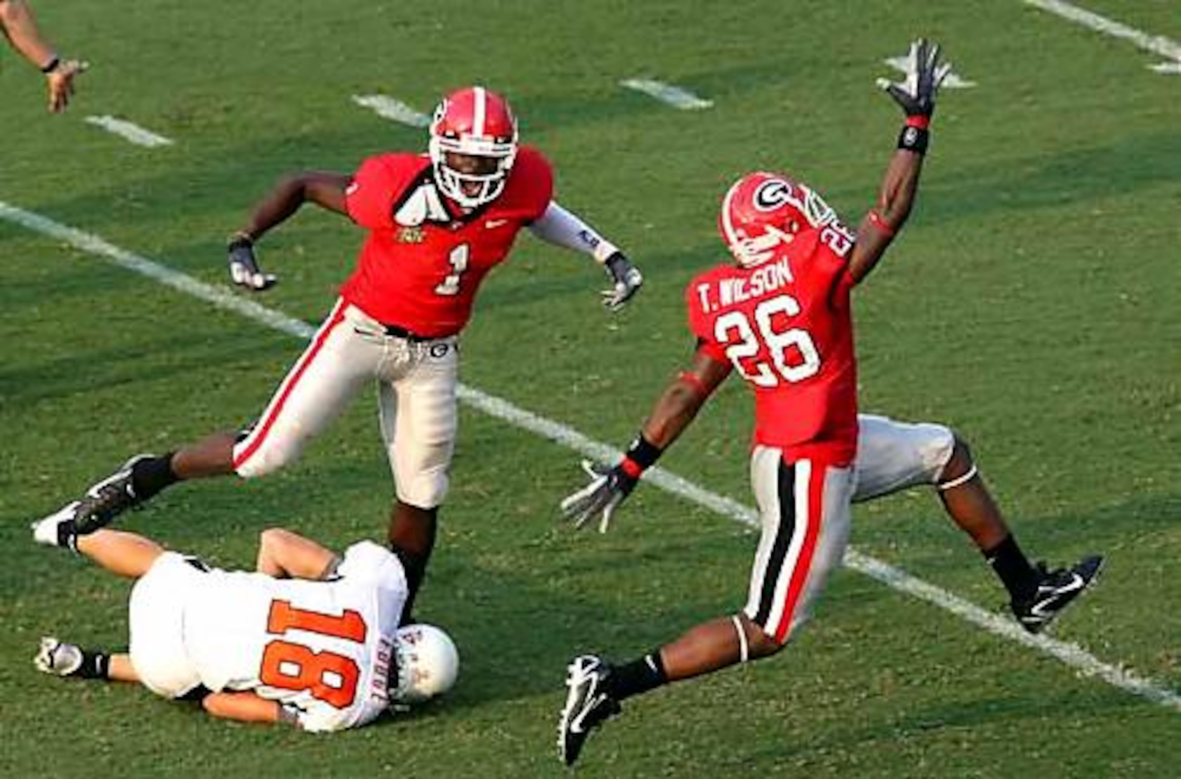 Georgia wide receiver Mohamed Massaquoi (1) and teammate Tony Wilson (26) celebrate after Massaquoi tackles Oklahoma State punter Matt Fodge (18) for a big loss on a bad hike that sets up a UGA touchdown.
