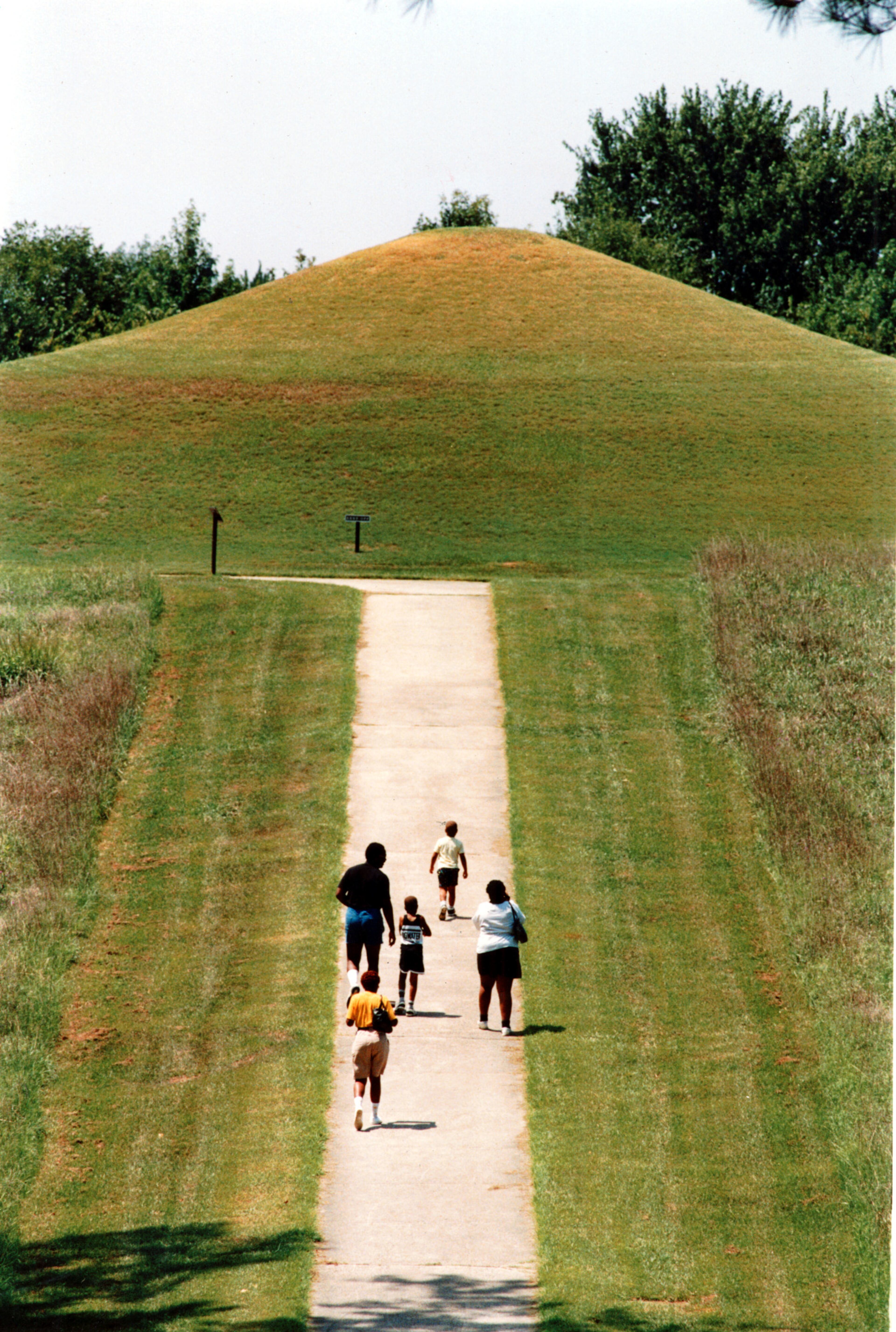 A vacationing family heads toward one of the mounds at the Ocmulgee National Monument in Macon. Artifacts dating back 12,000 years have been found at the site. Native Americans first came here during the Paleo-Indian period hunting Ice Age mammals. Different cultures occupied this land for thousands of years. The Mississippian culture arrived here around 900 constructing mounds for their elite. For directions to the Ocmulgee National Monument, please visit the National Park Service's website: http://www.nps.gov/ocmu/planyourvisit/directions.htm. -- Information and text from NPS.gov