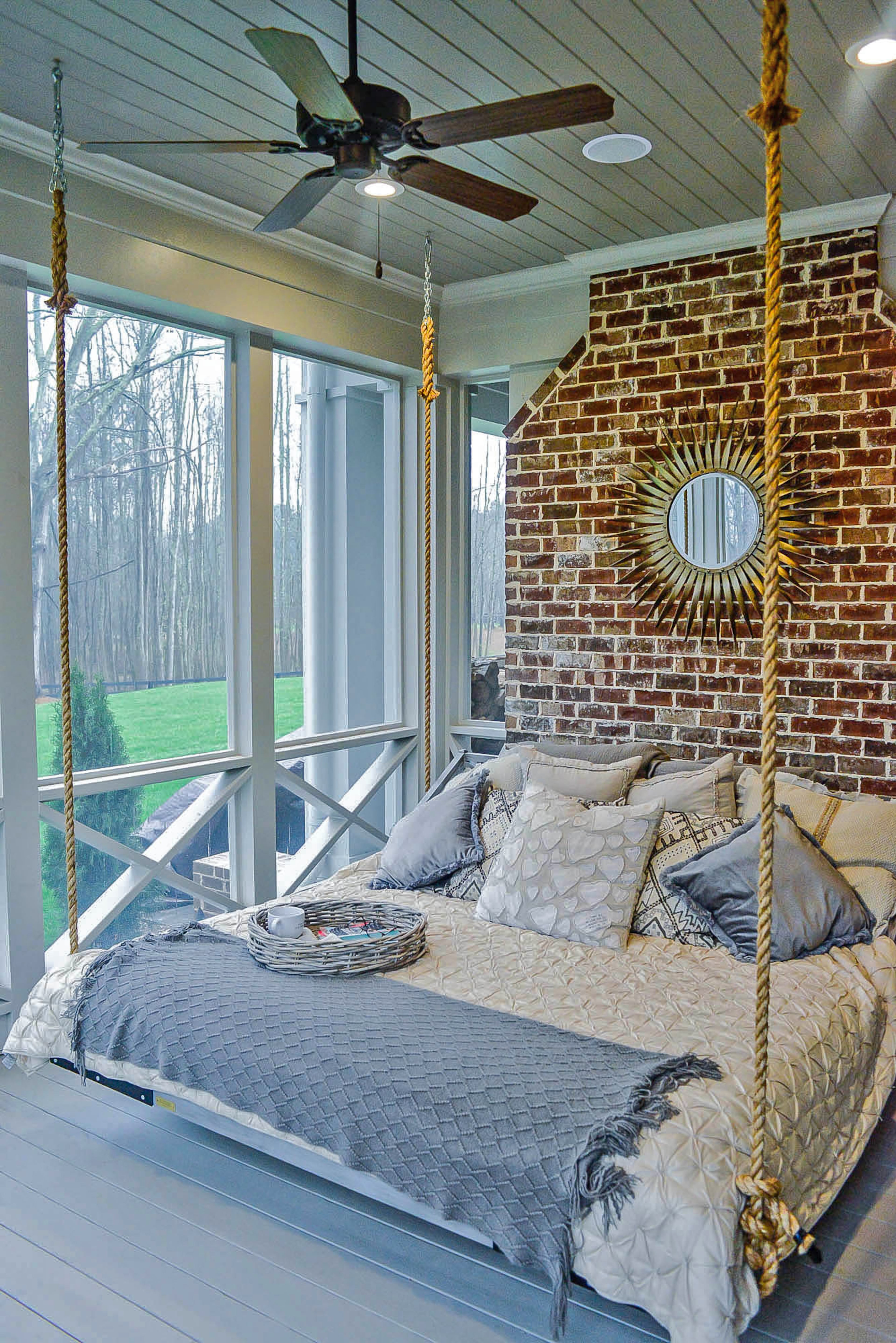 A swing bed is suspended from the ceiling with rope on the screened porch. It gives the Canton homeowners a comfortable perch to see the surroundings.