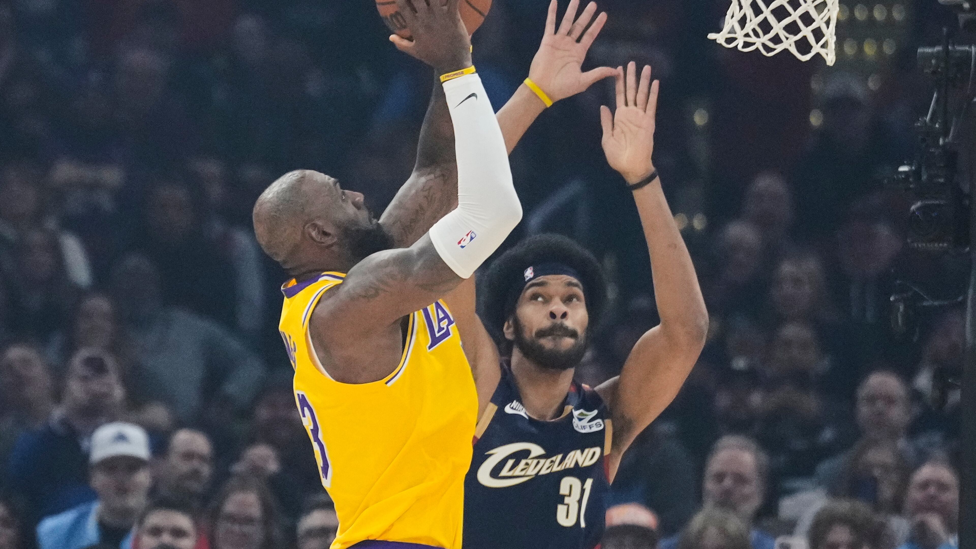 Los Angeles Lakers forward LeBron James left, shoots over Cleveland Cavaliers center Jarrett Allen (31) in the first half of an NBA basketball game in Cleveland, Wednesday, Jan. 28, 2026. (AP Photo/Sue Ogrocki)