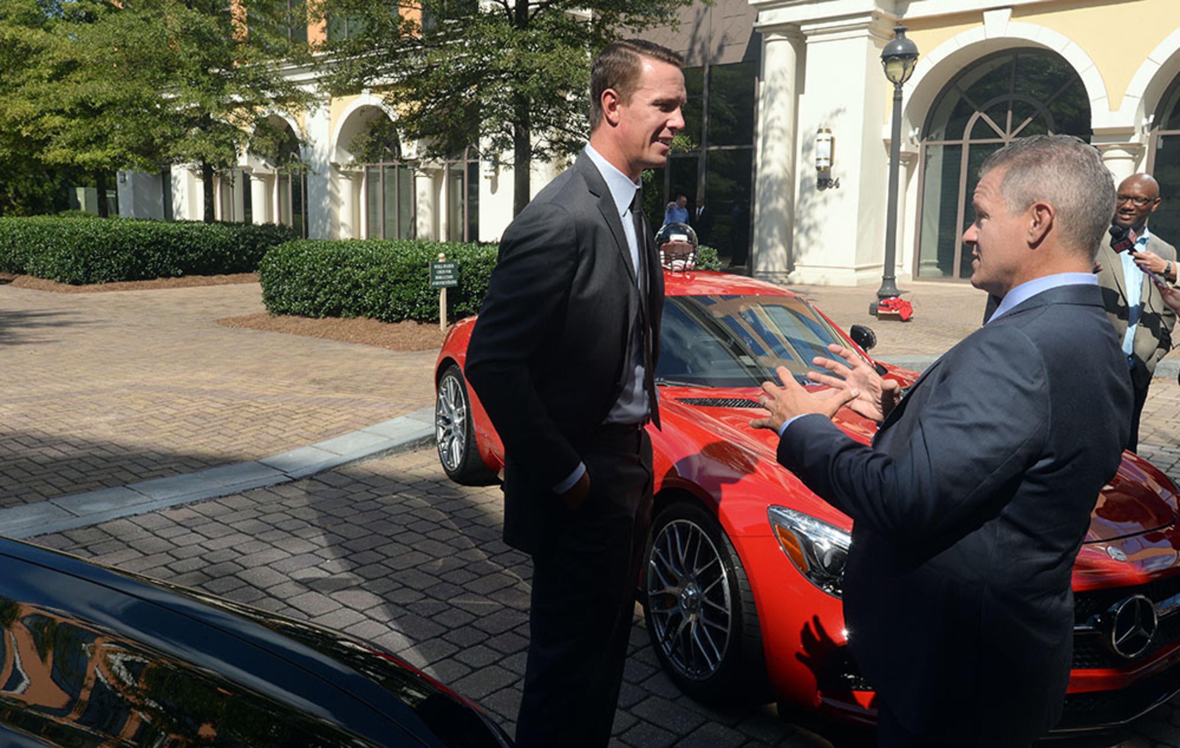 Falcons quarterback Matt Ryan talks with Stephen Cannon, Mercedes-Benz USA president and CEO, amid a display of the German luxury carmakers' vehicles, following the press conference announcing a deal for the naming rights for the new Falcons stadium, Monday, Aug. 24, 2015, in Atlanta.