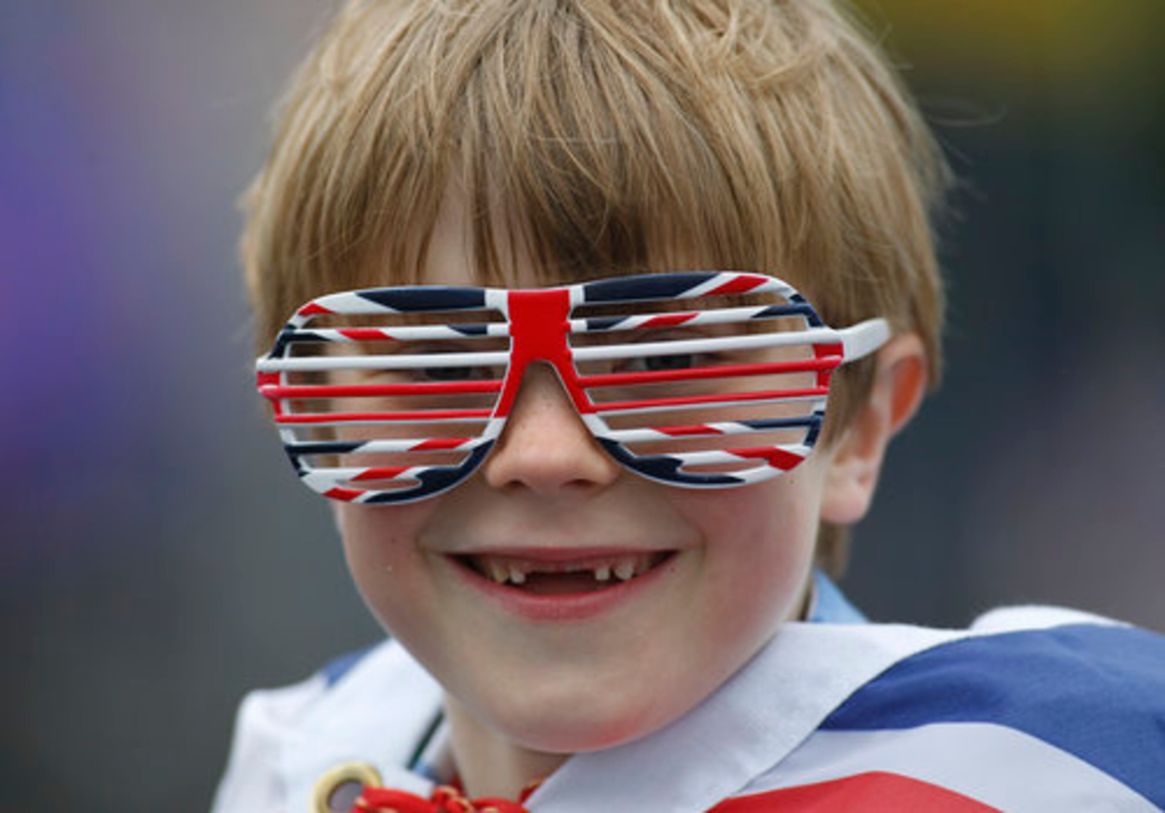 Owen Lewis, 7, looks on at Tower Bridge as thousands of people gather along the river Thames in London waiting for Britain's Queen Elizabeth II flotilla of boats to sail past in a river pageant.