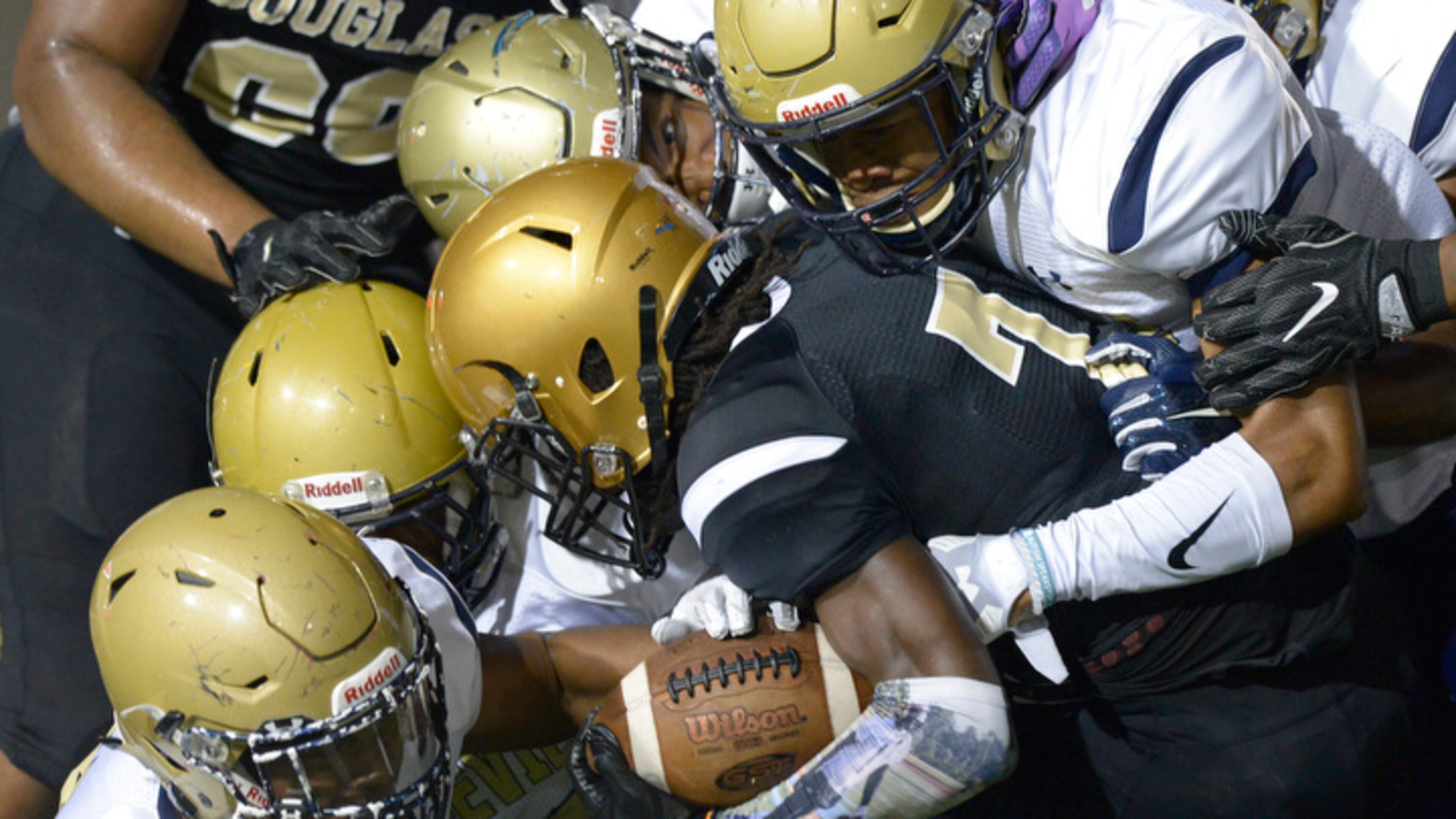 Friday Night football: Douglass senior QB Juan Powell (7) is smothered by the Hapeville Charter defense during Friday's game at Lakewood Stadium. (Daniel Varnado/Special)