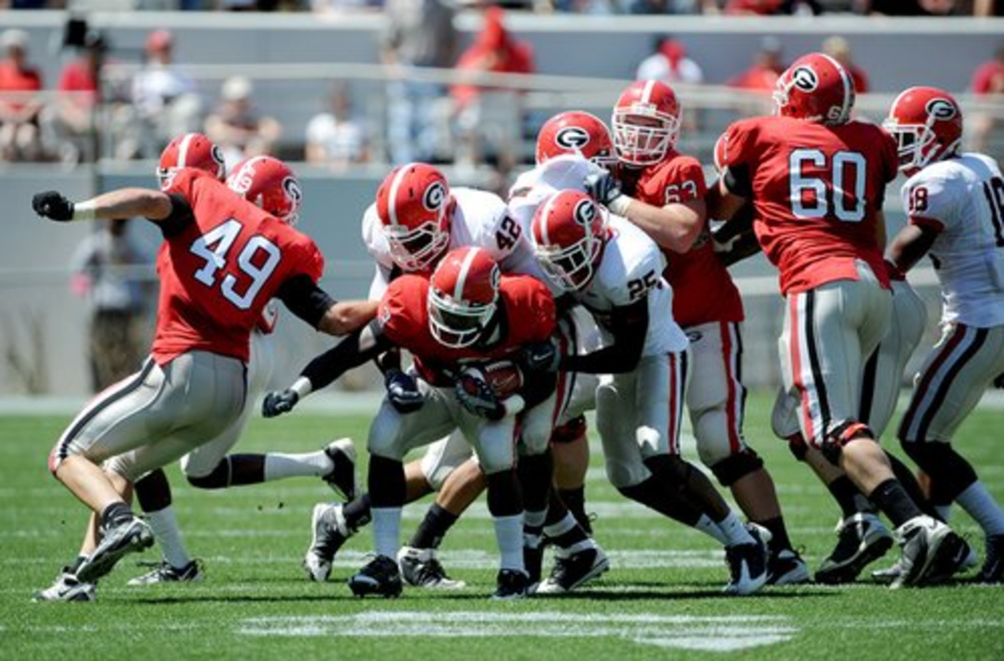 Georgia running back Washaun Ealey (3) is tackled by Justin Houston (42) and Vance Cuff (25) as the defense gets penetration during the first half.