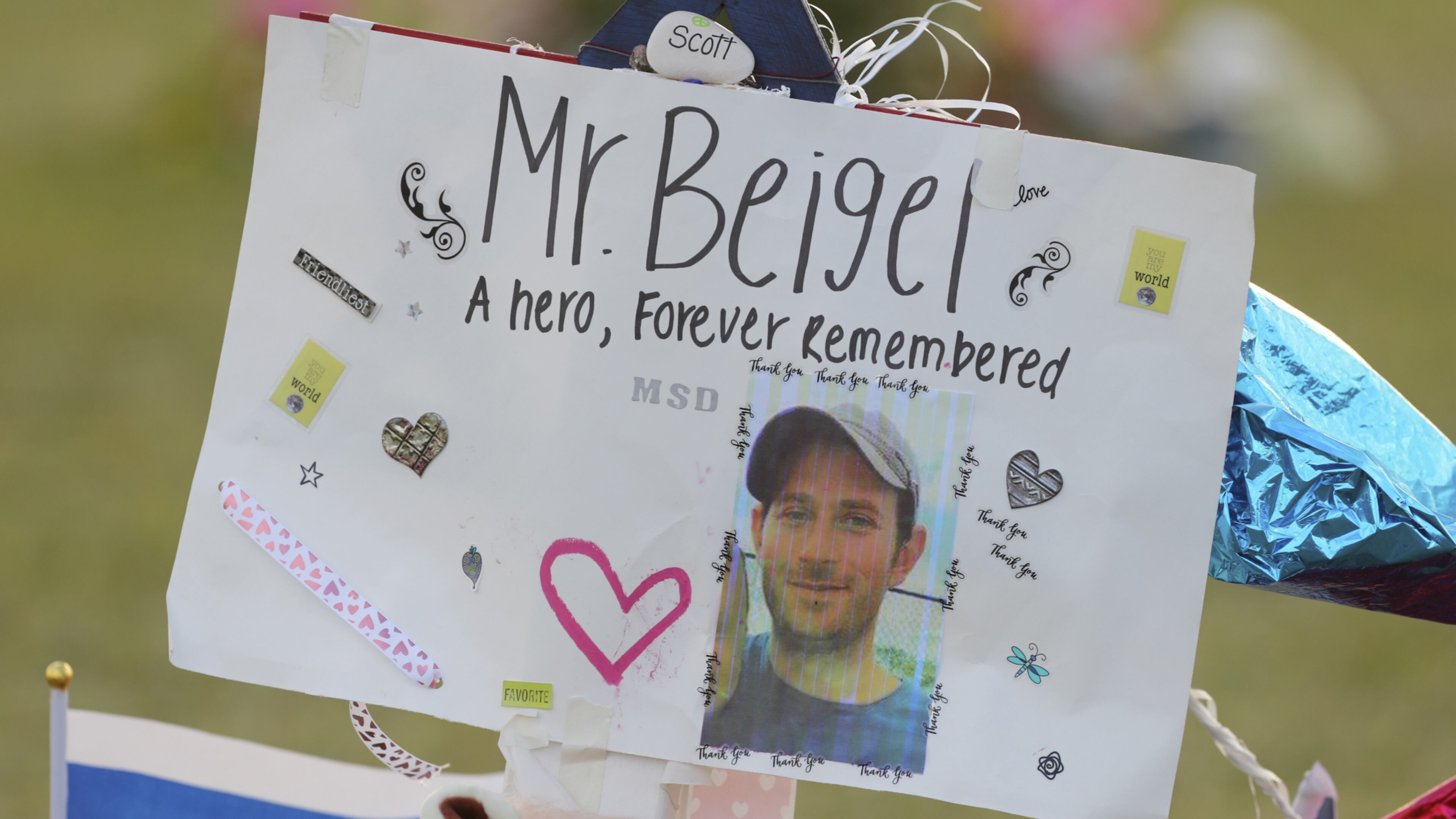 A memorial for Geography teacher and cross-country coach, Scott Beigel is shown on Tuesday Feb. 20, 2018 at Pine Trails Park in Parkland, Fla. Members of the Marjory Stoneman Douglas High School cross country team organized a run to honor their fallen coach, Scott Beigel, and the other victims of the school shooting. (Mike Stocker/South Florida Sun-Sentinel via AP)