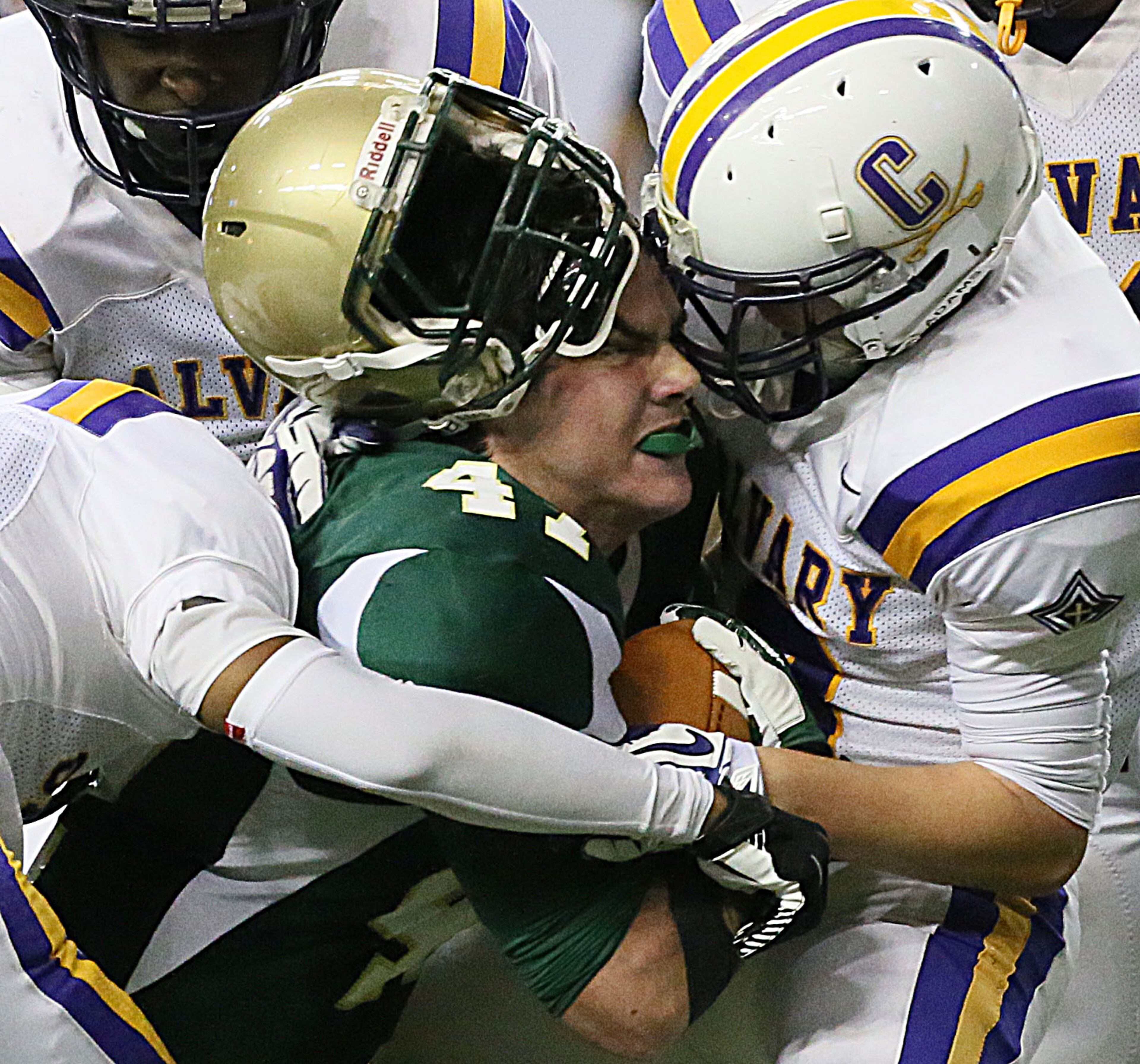 Aquinas High School's (Augusta) # 47 Chris Lambert looses his helmet as she pushes through Calvary Day School (Savannah) defenders during their GHSA Football A-Private State Championship game at the Georgia Dome in Atlanta on Friday December 13th, 2013.