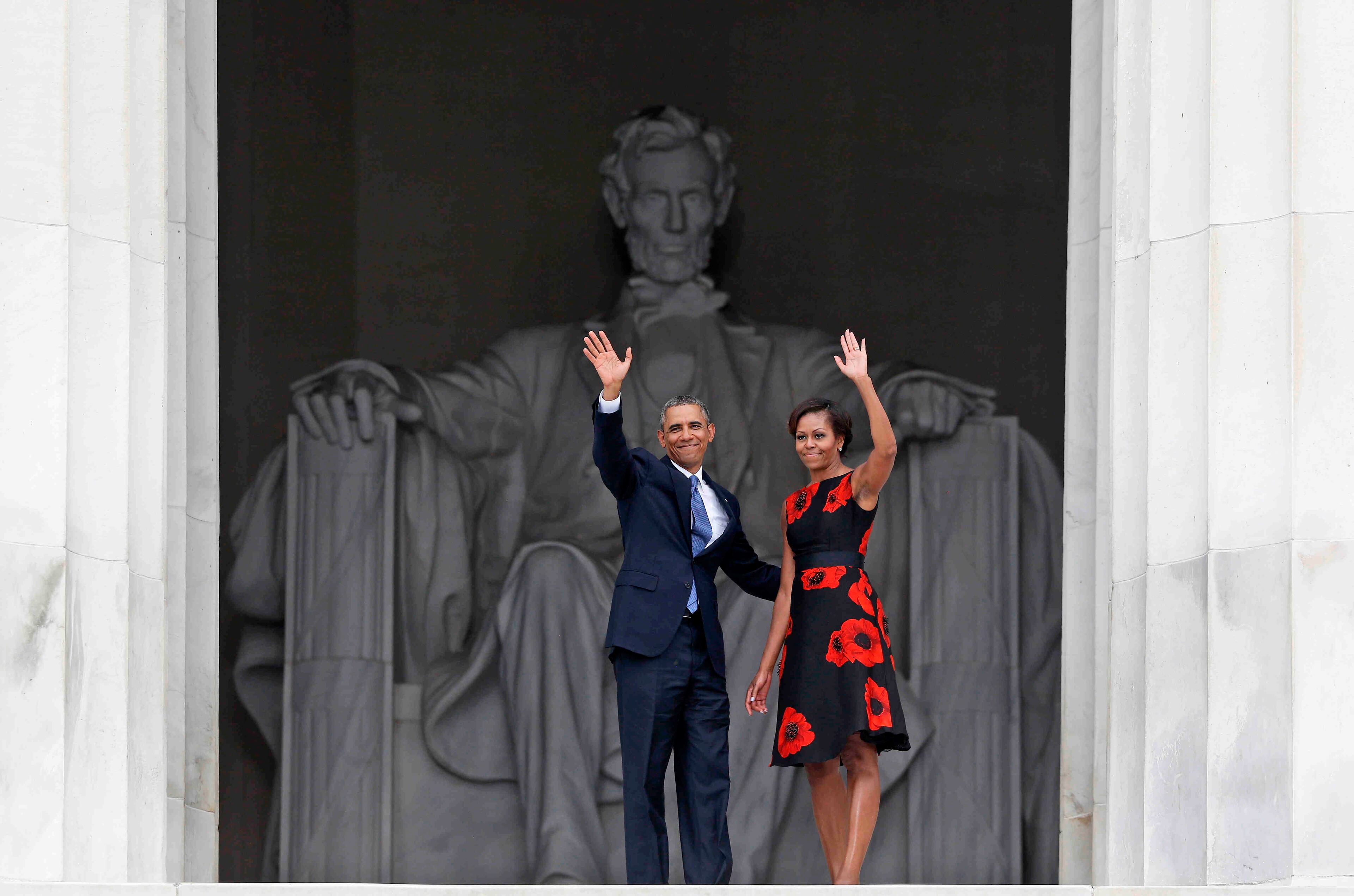 President Barack Obama and first lady Michelle Obama wave as they leave 50th Anniversary of the March on Washington where Martin Luther King Jr. spoke, Wednesday, Aug. 28, 2013, at the Lincoln Memorial in Washington. (AP Photo/Charles Dharapak)