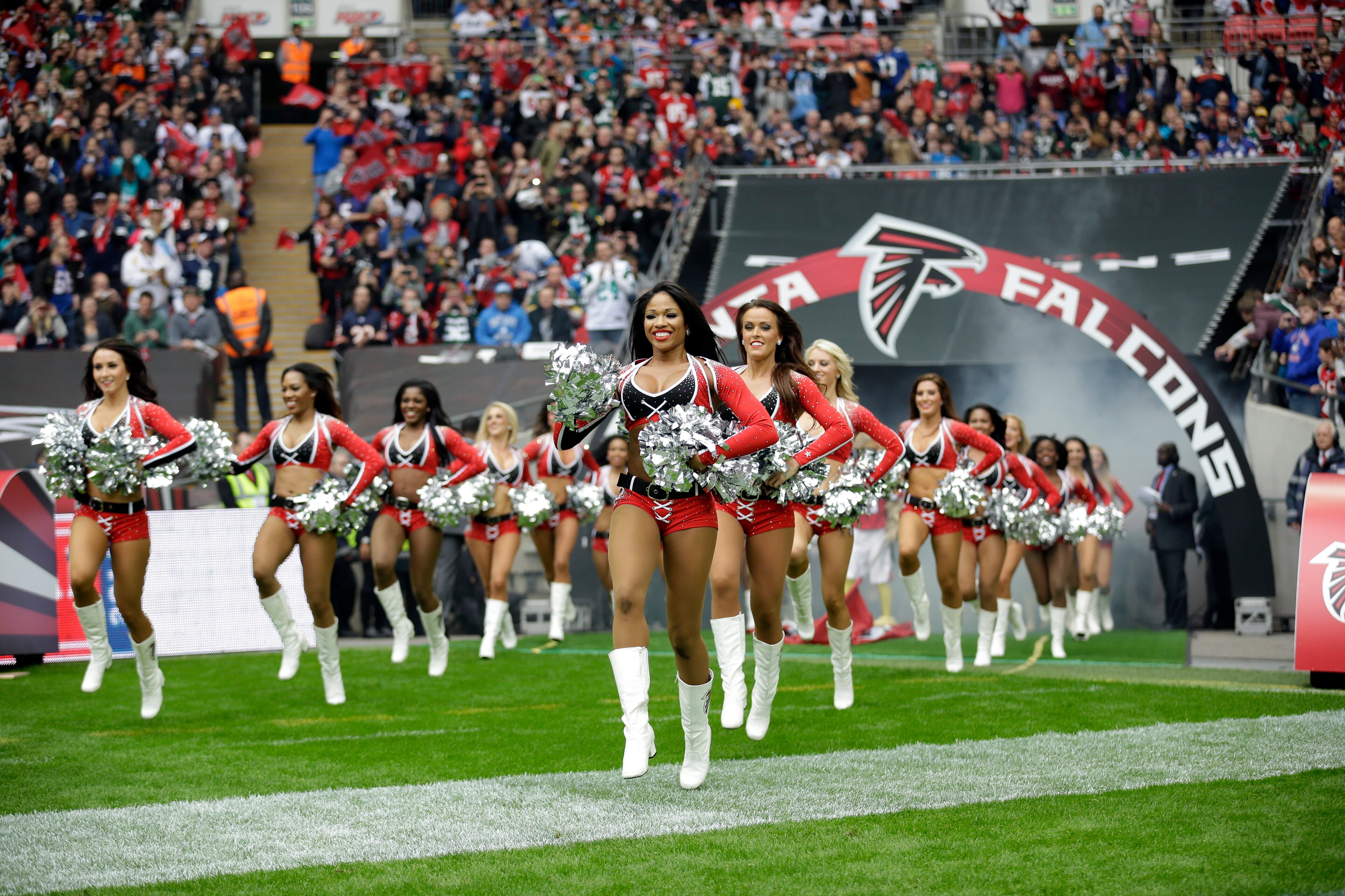 Atlanta Falcons cheerleaders run to the field before the NFL football game between the Atlanta Falcons and the Detroit Lions at Wembley Stadium, London, Sunday, Oct. 26, 2014. (AP Photo/Matt Dunham)