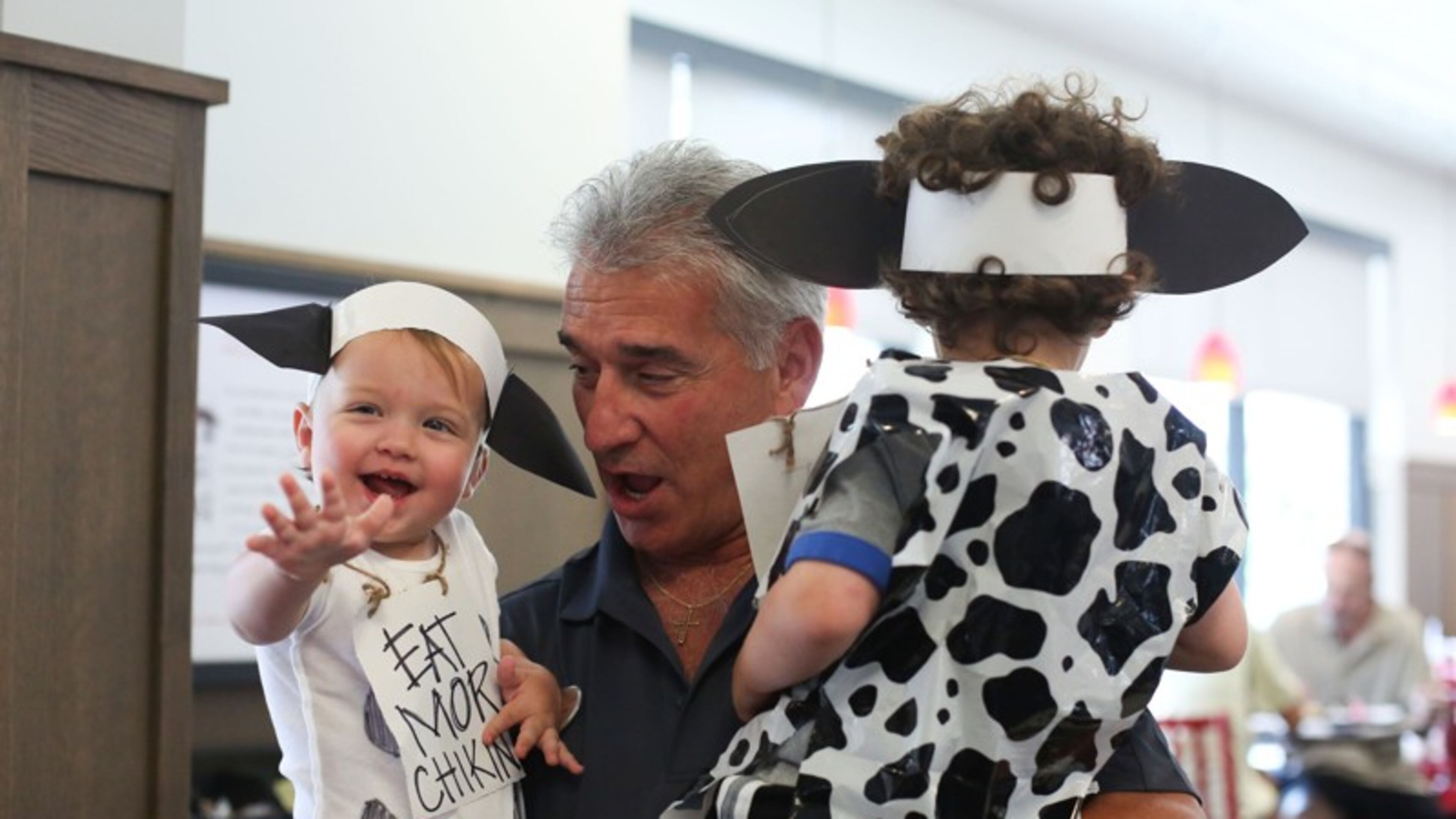 Alex Rodriguez, store operator at Chick-fil-A on Hammond Drive in Atlanta, greets Issac Timberline, 1, and Nolan Timberline, 3, on Cow Appreciation Day 2016.