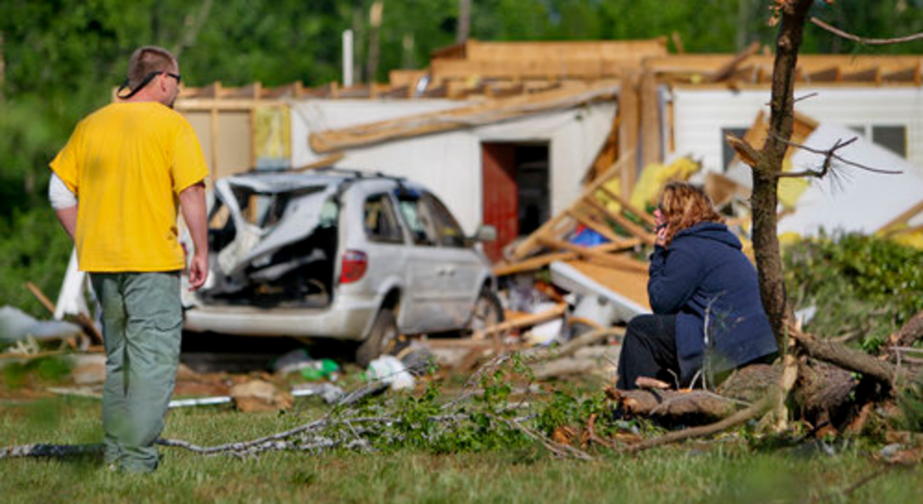 Joe and Stacey Peavy gather their wits as they look where their 13-year-old daughter Kylie was swept up by a tornado. Kylie had no serious injury.