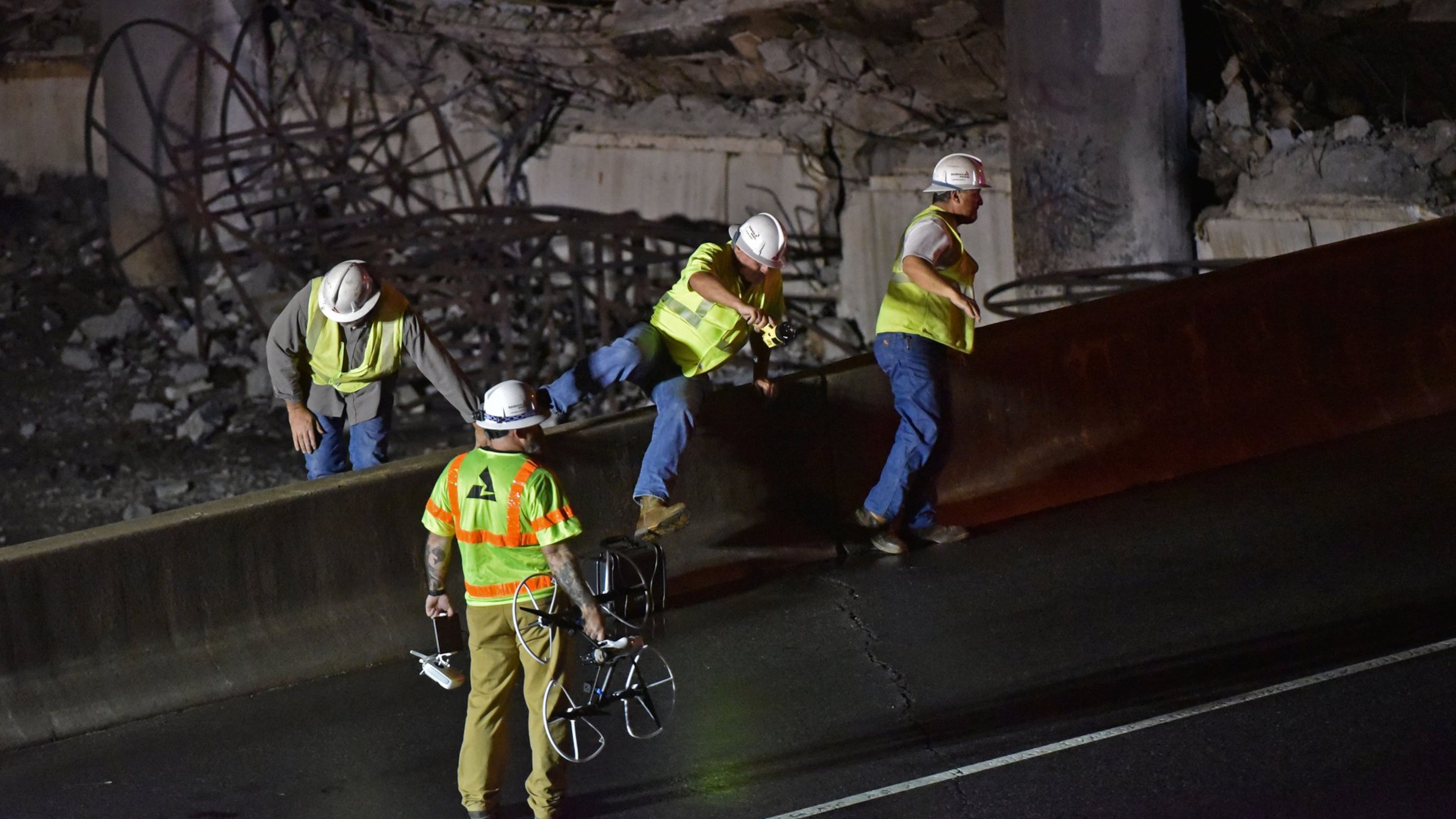 March 30, 2017 Atlanta - Crew surveys the section of an overpass that collapsed from a fire on I-85 on Thursday, March 30, 2017. Fire officials extinguished a massive fire on I-85 on Thursday night after it burned for more than an hour and led to the collapse of a bridge on the interstate, fire officials said. HYOSUB SHIN / HSHIN@AJC.COM