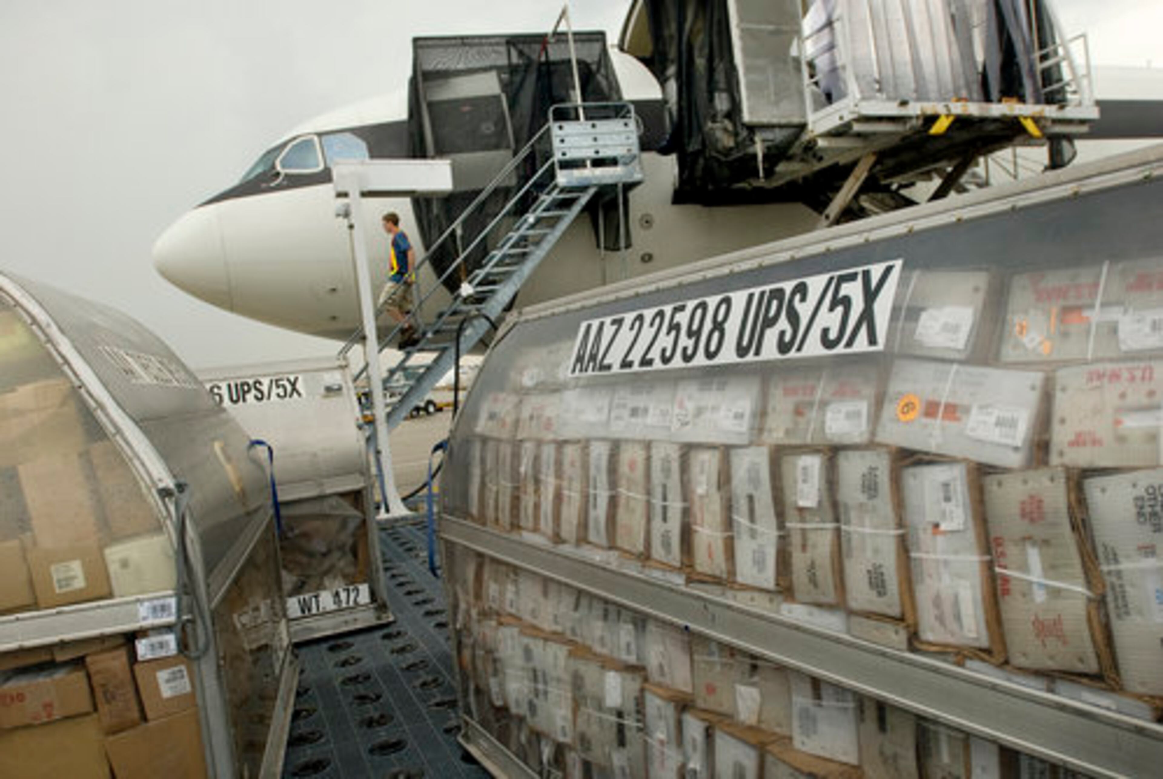 Aircraft fueler Jason Key leaves the cockpit of a plane surrounded by packages.