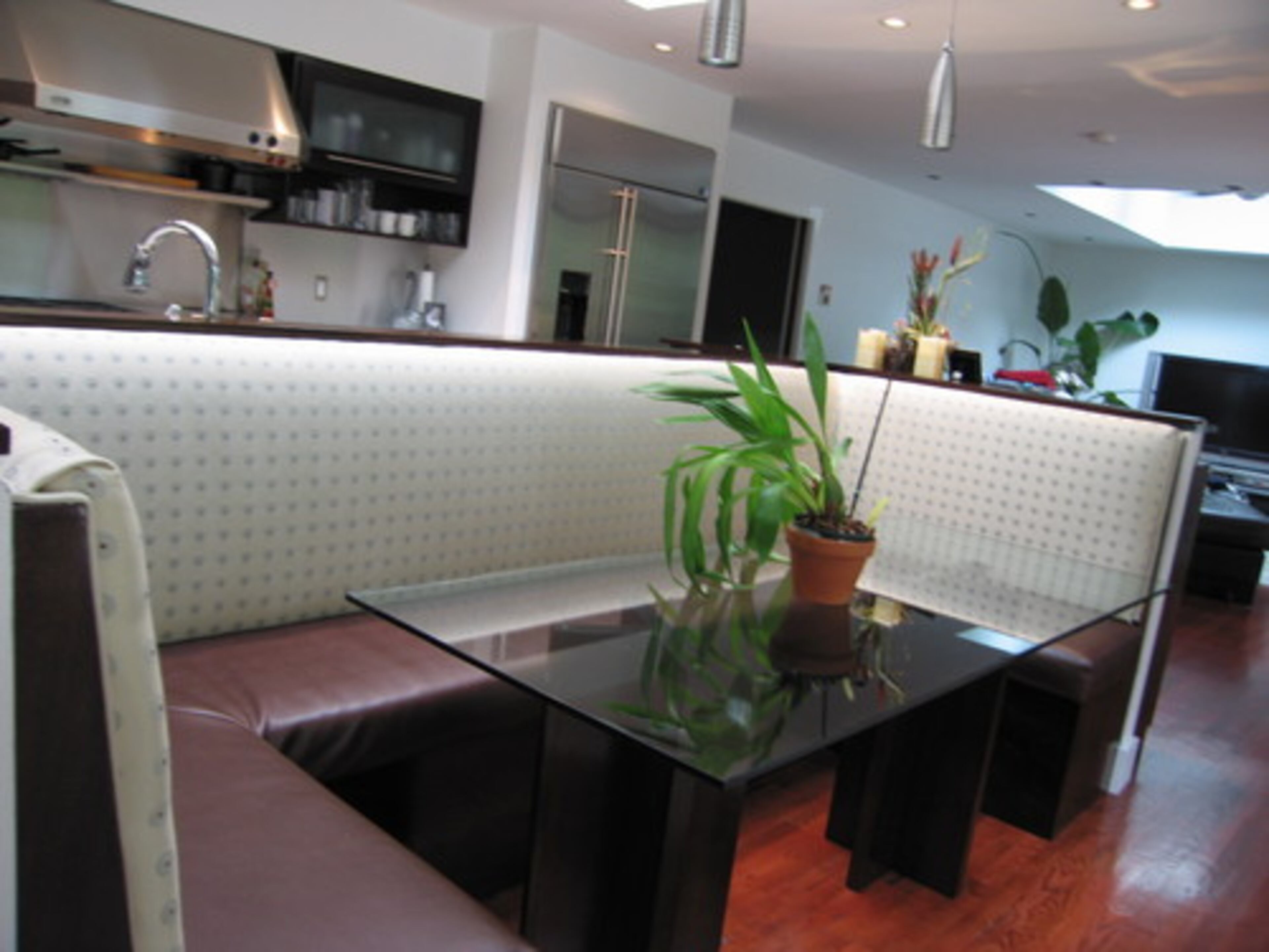 UNIQUE FEATURE: On the other side of the kitchen island, Lake designed a banquette at her husband's request. "I like the idea of facing a window, but not being up against it," she said. The couple installed red-stained oak floors throughout the kitchen and living area.