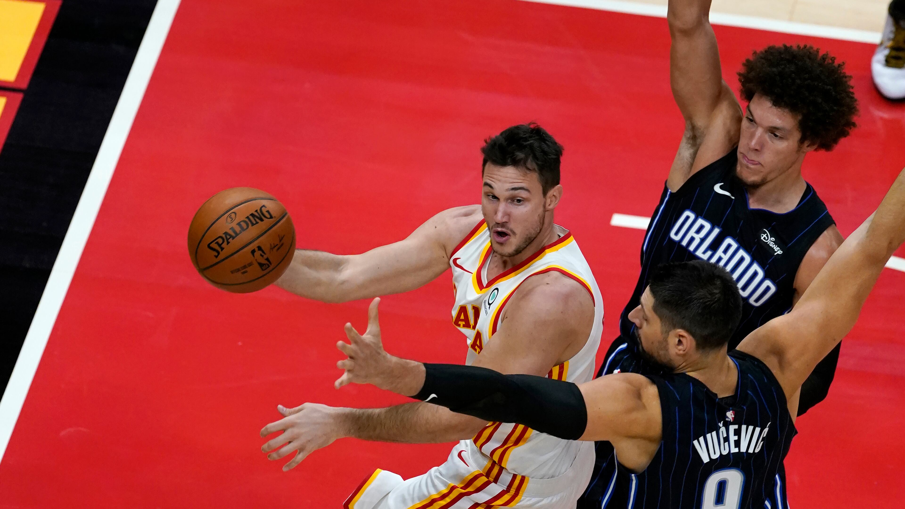 Atlanta Hawks forward Danilo Gallinari (left) passes the ball as Orlando Magic's Aaron Gordon (right) and Nikola Vucevic (center) defends during the first half Sunday, Dec. 13, 2020, in Atlanta. (John Bazemore/AP)