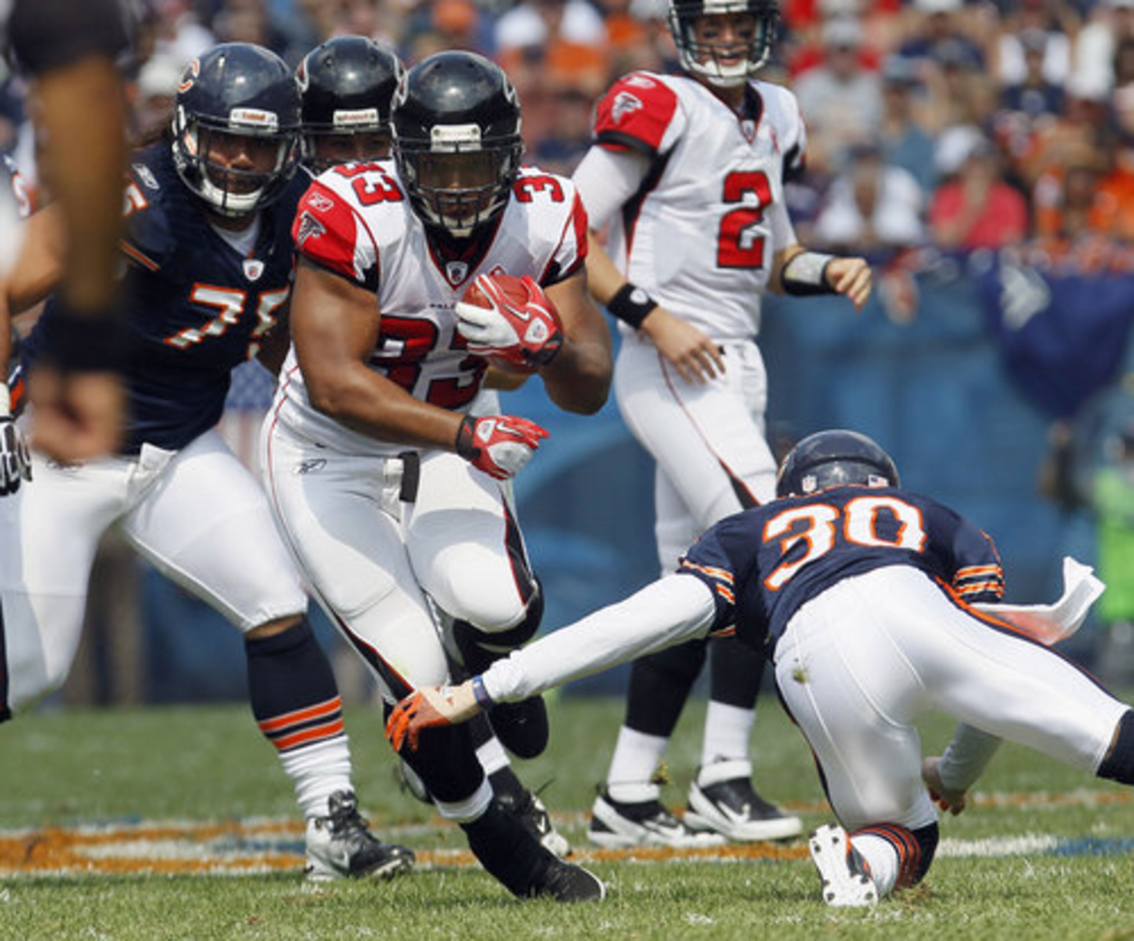 Atlanta Falcons running back Michael Turner (33) picks up yardage past Chicago Bears' D.J. Moore (30) and Matt Toeaina (75).