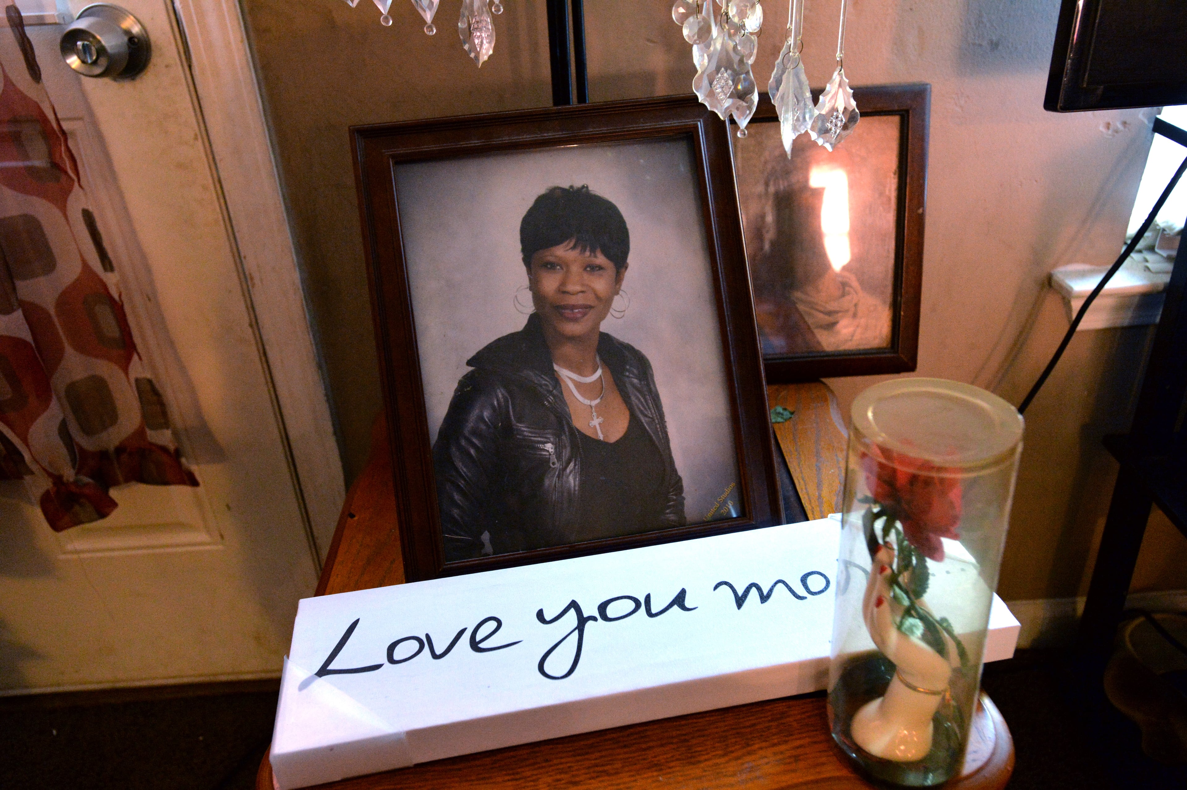 After Donna Woods’ death in September, her children created a kind of shrine to her memory, featuring a favorite portrait of their mother in healthier times and an inscription that echoes the words she often told her kids: “Love you more.” HYOSUB SHIN / HSHIN@AJC.COM