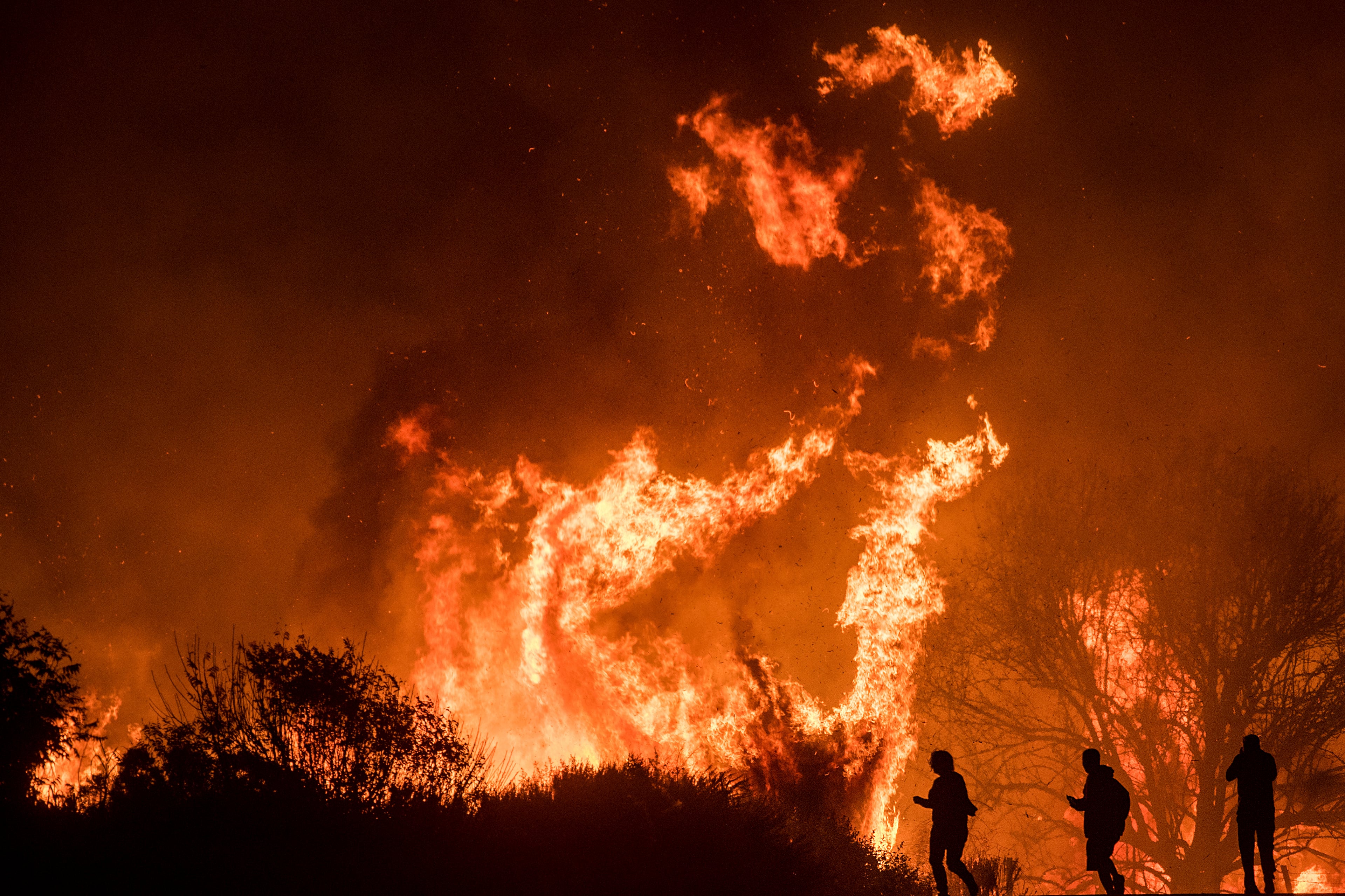 Flames from the Thomas fire burn above a truck on Highway 101 north of Ventura, Calif., on Wednesday, Dec. 6, 2017.