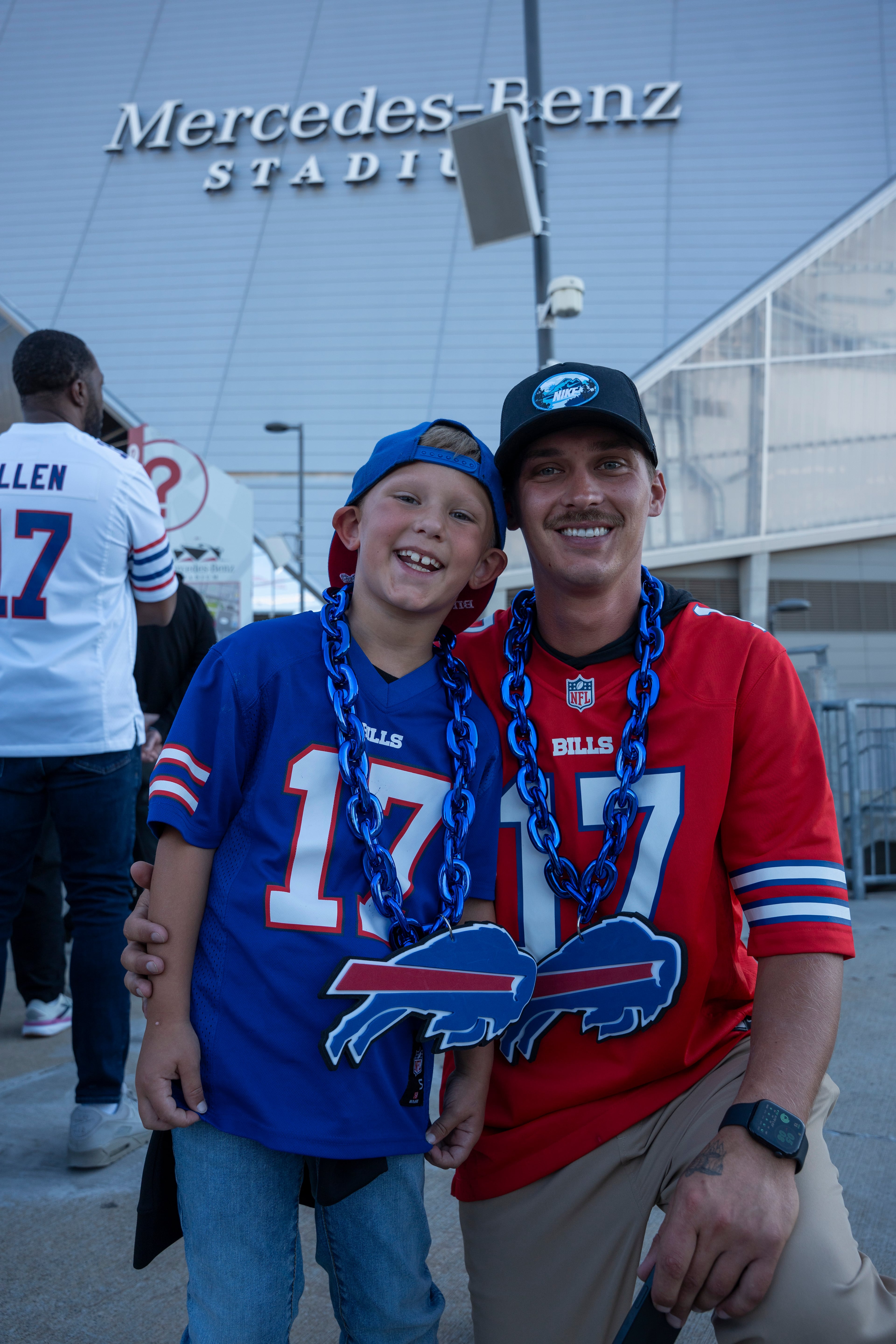 Chase Harris and his 6-year-old son, Easton, from Bethlehem, Ga., pose in Buffalo Bills jerseys outside Mercedes-Benz Stadium on Monday, Oct. 13, 2025, in Atlanta, before the Monday Night Football game between the Bills and the Falcons. (Olivia Bowdoin for the AJC)
