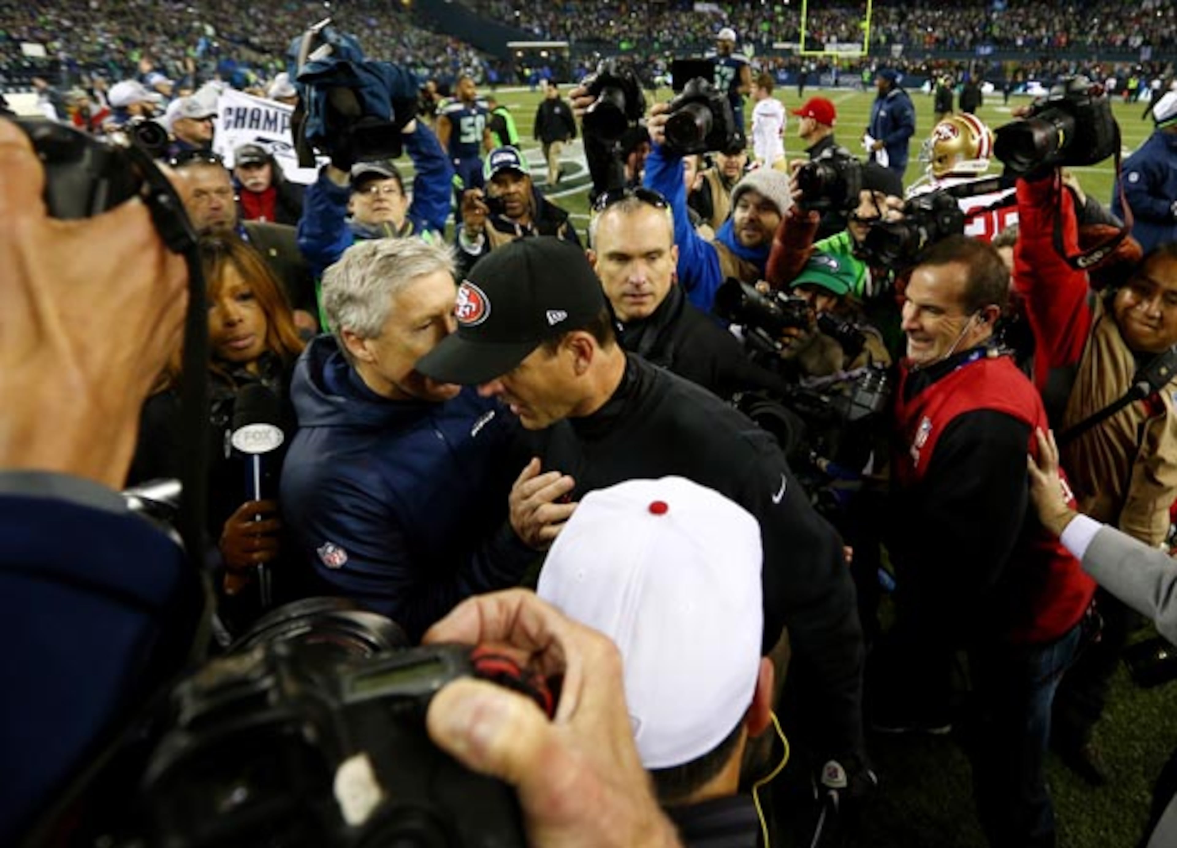 SEATTLE, WA - JANUARY 19: Head coach Pete Carroll of the Seattle Seahawks and head coach Jim Harbaugh of the San Francisco 49ers shake hands after the Seahawks 23-17 victory during the 2014 NFC Championship at CenturyLink Field on January 19, 2014 in Seattle, Washington. (Photo by Tom Pennington/Getty Images)