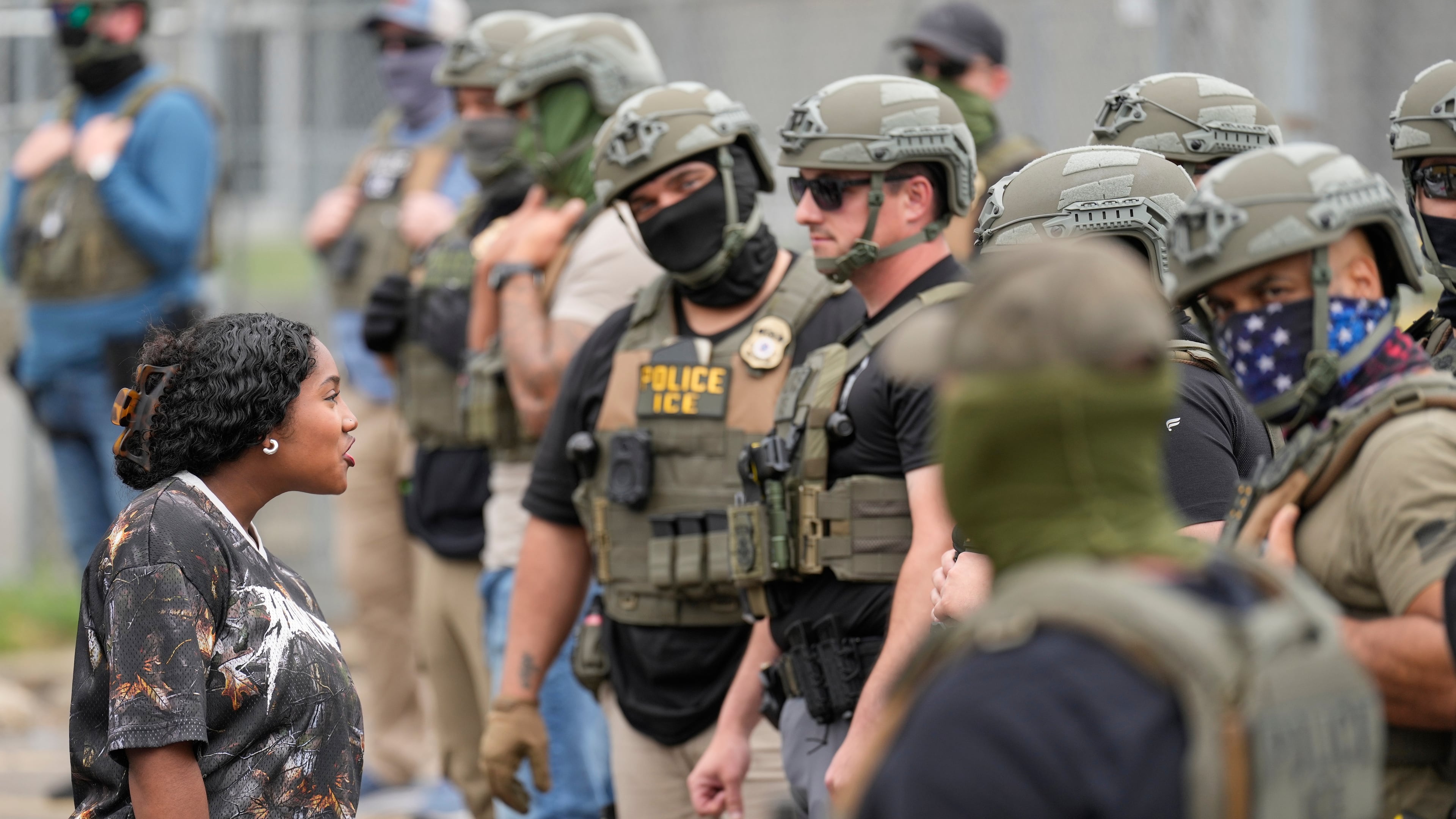 A protester talks to masked federal agents standing outside the Delaney Hall detention center during a protest against the transfer of detainees on Wednesday, May 27, 2026, in Newark, N.J. (AP Photo/Seth Wenig)