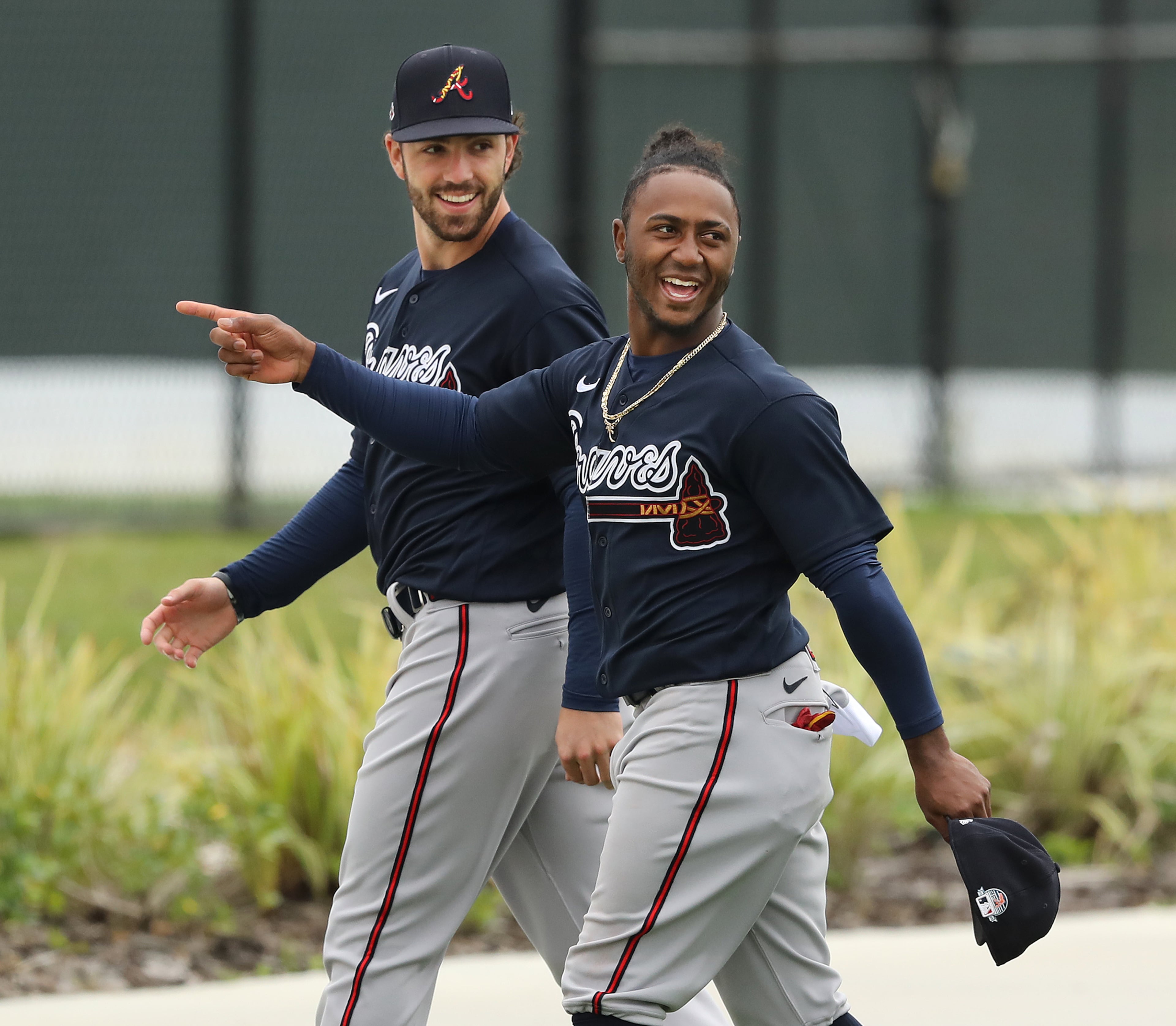 Infielders Dansby Swanson and Ozzie Albies share a laugh on the way to a practice field Friday. (Curtis Compton/ccompton@ajc.com)