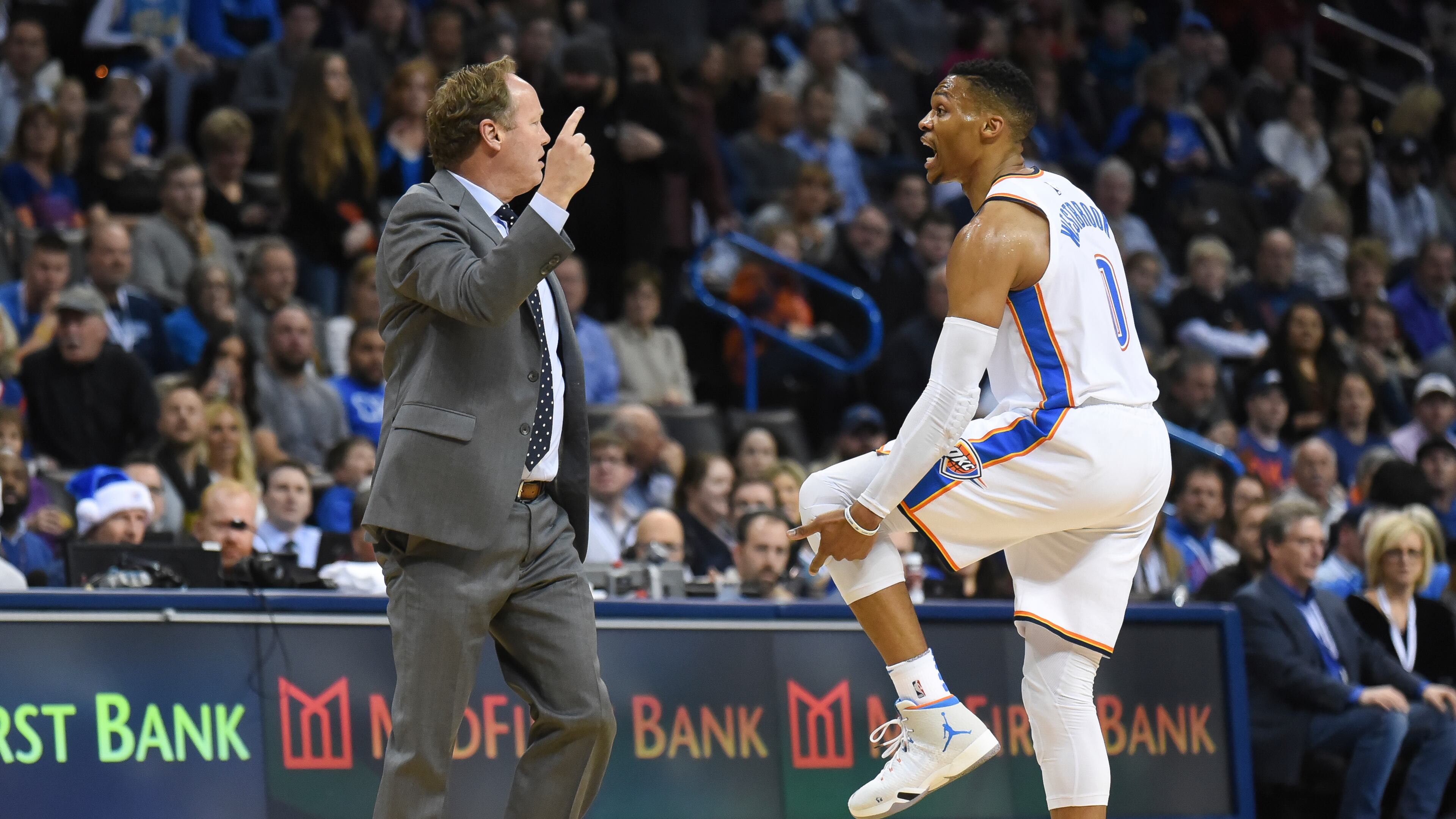Atlanta Hawks head coach Mike Budenholzer, left, argues with Oklahoma City Thunder's Russell Westbrook, right, about a foul in the first quarter of an NBA basketball game in Oklahoma City, Friday, Dec. 22, 2017. (AP Photo/Kyle Phillips)