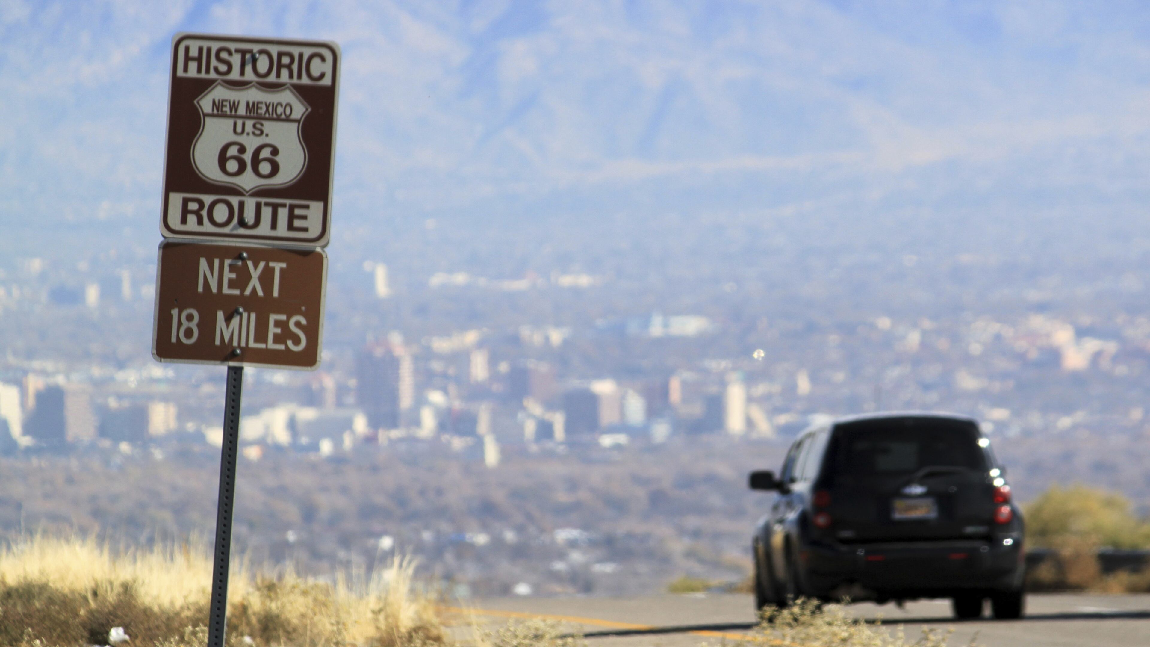 FILE--In this Nov. 19, 2014, file photo, a car travels down historic Route 66 toward Albuquerque, N.M. Route 66, the historic American roadway that linked Chicago to the West Coast, soon may be dropped from a National Park Service preservation program. A federal law authorizing the Route 66 Corridor Preservation Program is set to expire in two years and with it would go millions of dollars in grants for reviving old tourist spots in struggling towns. (AP Photo/Susan Montoya Bryan, file)