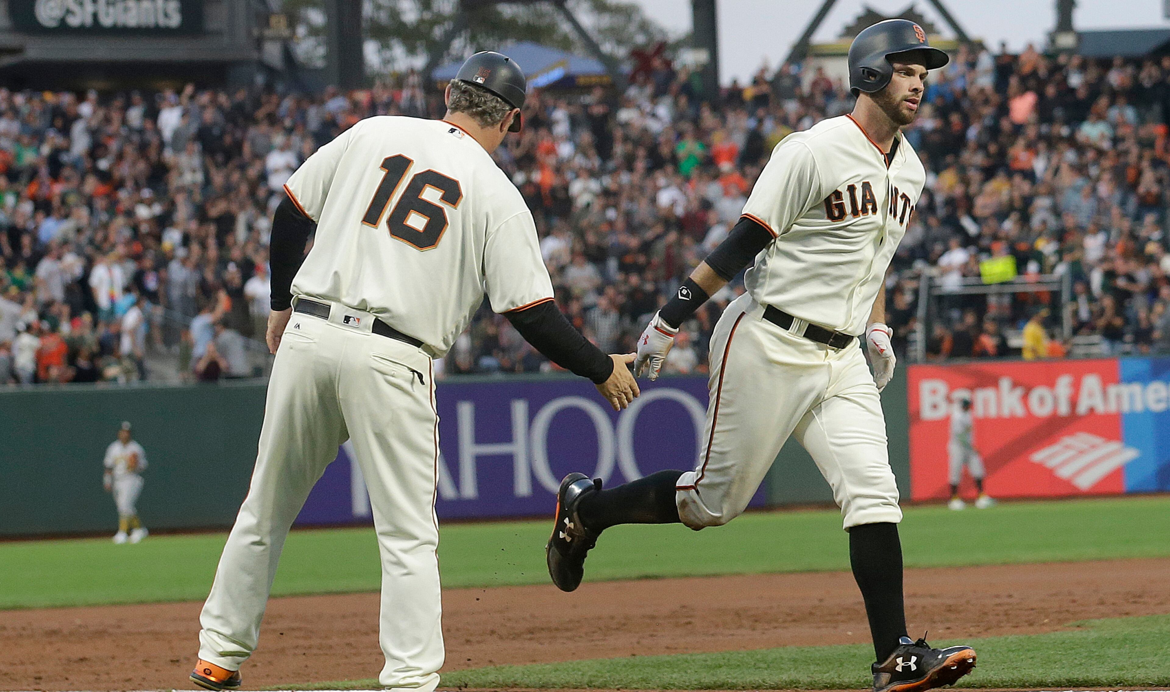 San Francisco Giants' Brandon Belt, right, is congratulated by third base coach Phil Nevin after hitting a two-run home run against the Oakland Athletics during the second inning of a baseball game in San Francisco, Thursday, Aug. 3, 2017. (AP Photo/Jeff Chiu)