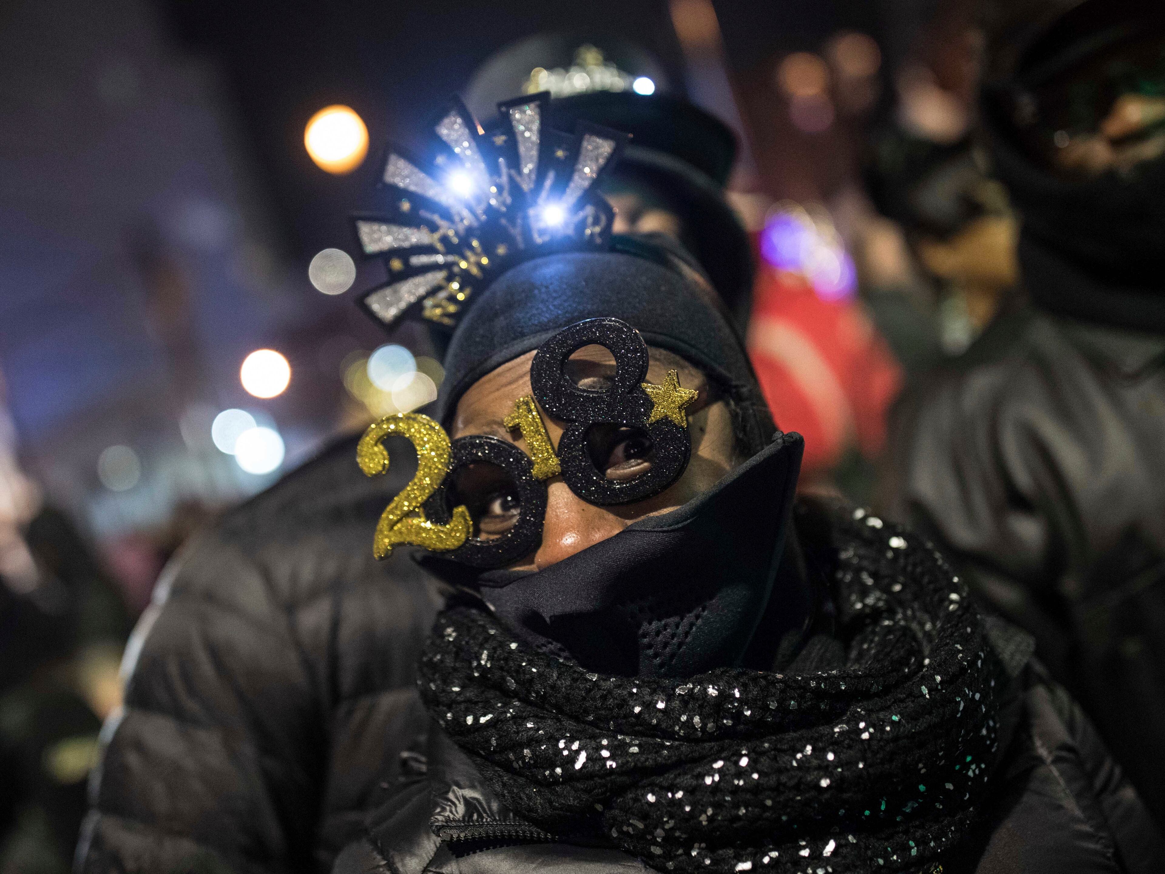 A woman wears 2018 glasses during the Peach Drop event at Woodruff Park in Atlanta, Sunday, Dec. 31, 2017. (Branden Camp/Atlanta Journal-Constitution via AP)