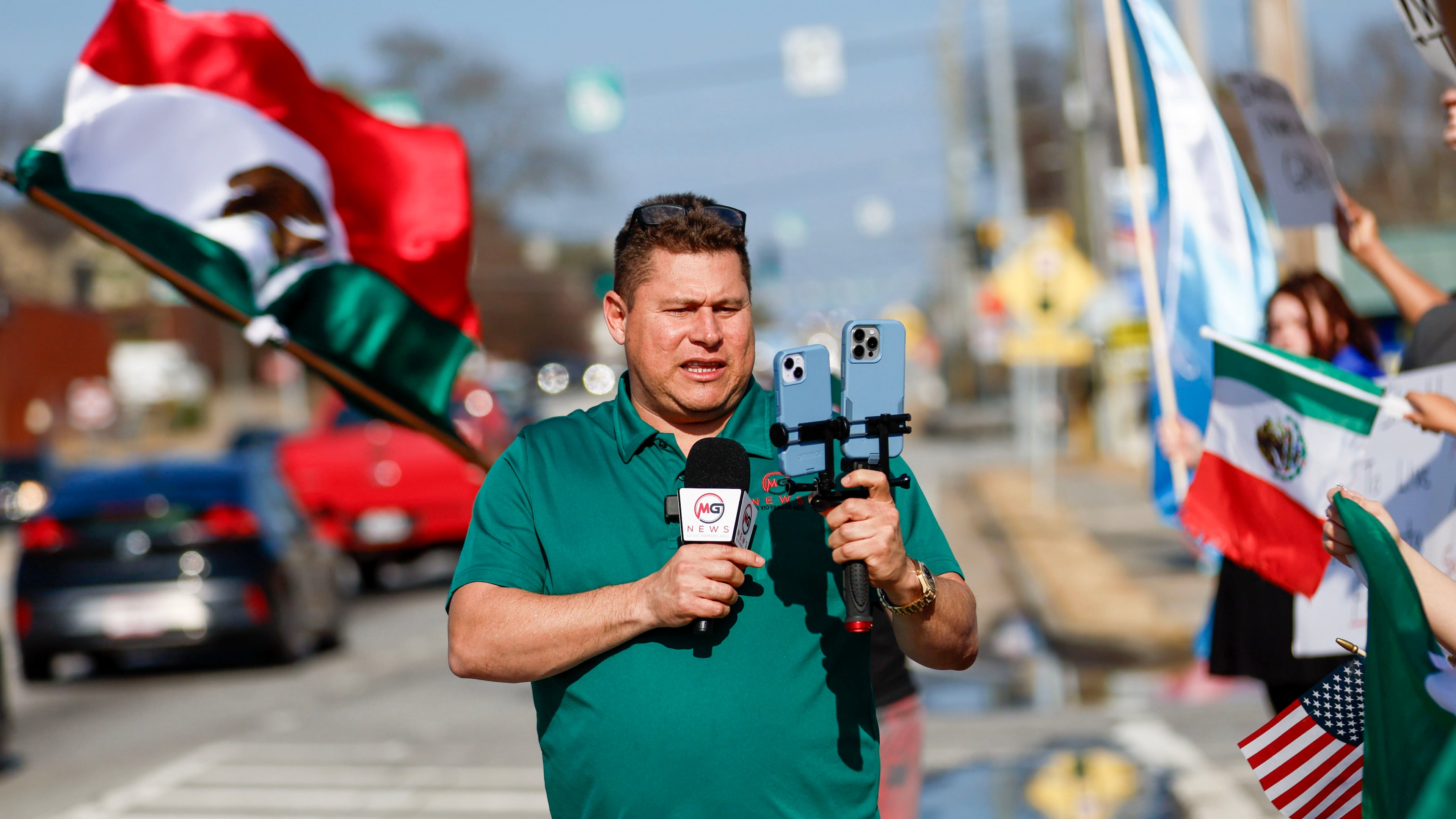 Mario Guevara covers a protest against immigration enforcement on Buford Highway on Saturday, February 1, 2025. (Miguel Martinez/AJC)