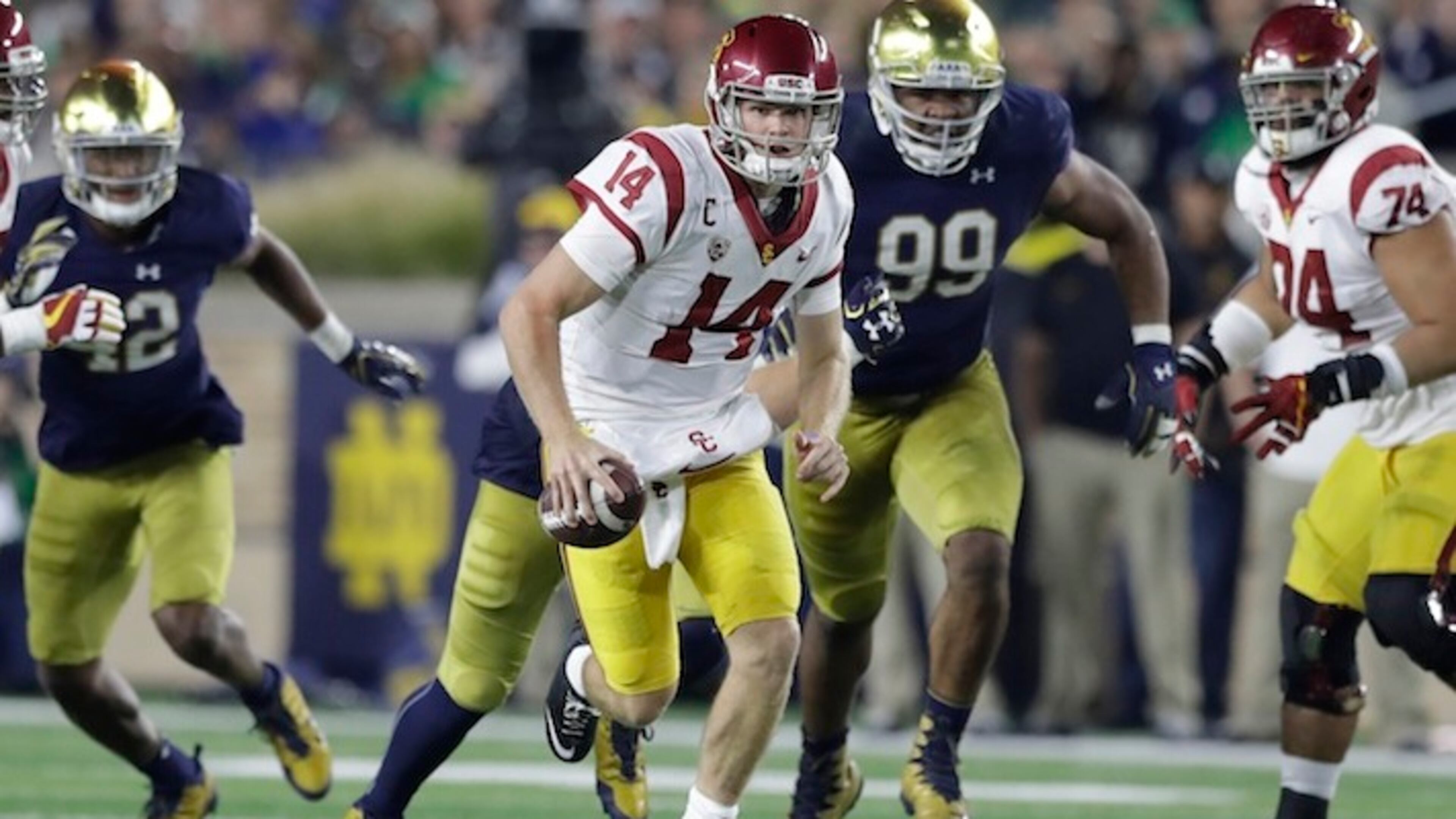 FILE - In this Oct. 21, 2017, file photo, Southern California quarterback Sam Darnold scrambles during the second half of an NCAA college football game against Notre Dame in South Bend, Ind. Darnold, a third-year sophomore, hasn't said yet if he will return to eight-ranked USC for another season or if the Cotton Bowl against fifth-ranked Ohio State will be his Trojans finale. He has to decide by Jan. 15 whether to make himself eligible for the next NFL draft, which will be held in late April in the same stadium where he will play Friday night. (AP Photo/Carlos Osorio, File)