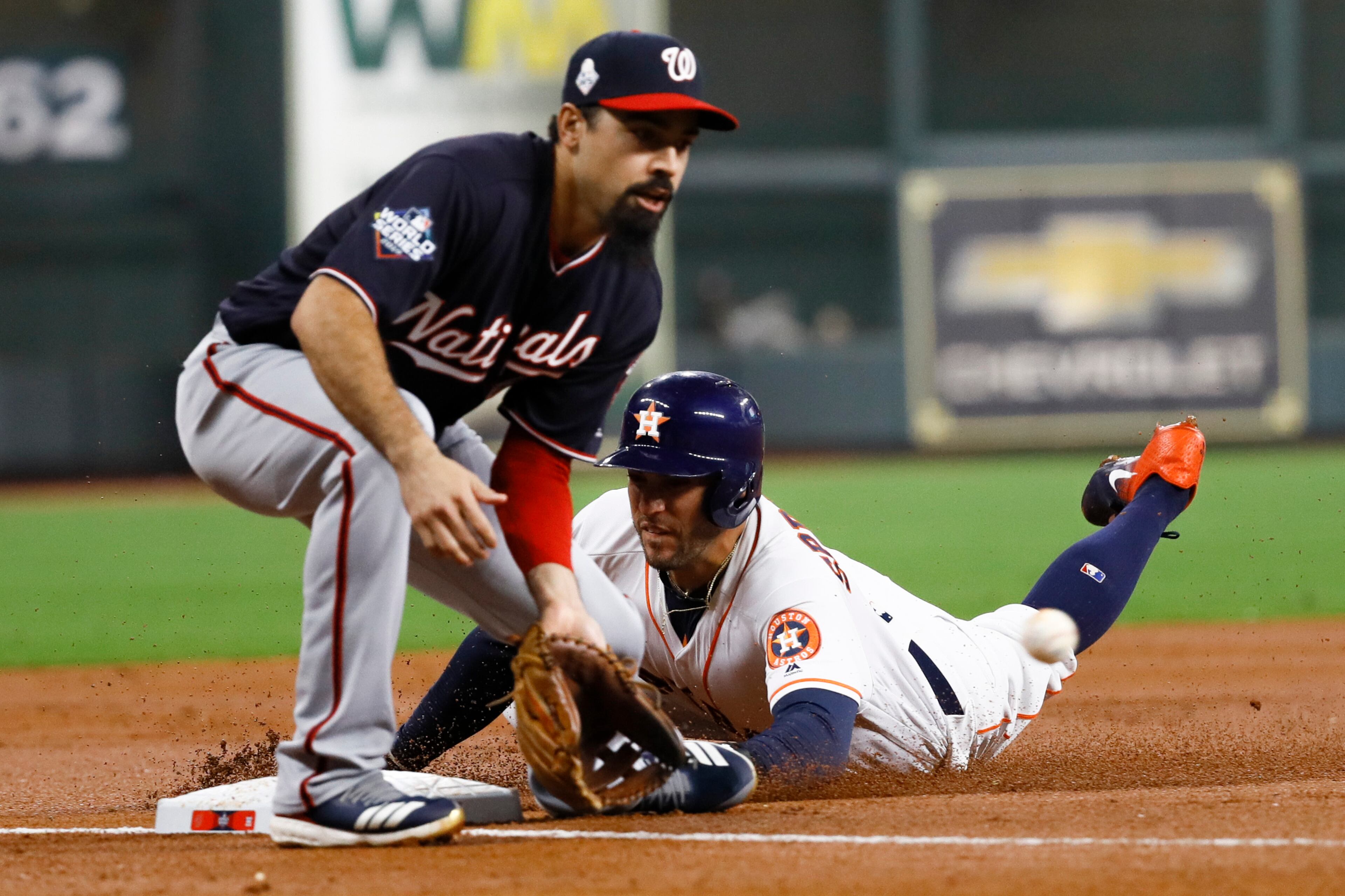 Houston Astros' George Springer is safe at third past Washington Nationals third baseman Anthony Rendon on a wild pitch during the first inning of Game 1 of the baseball World Series Tuesday, Oct. 22, 2019, in Houston. (AP Photo/Matt Slocum)
